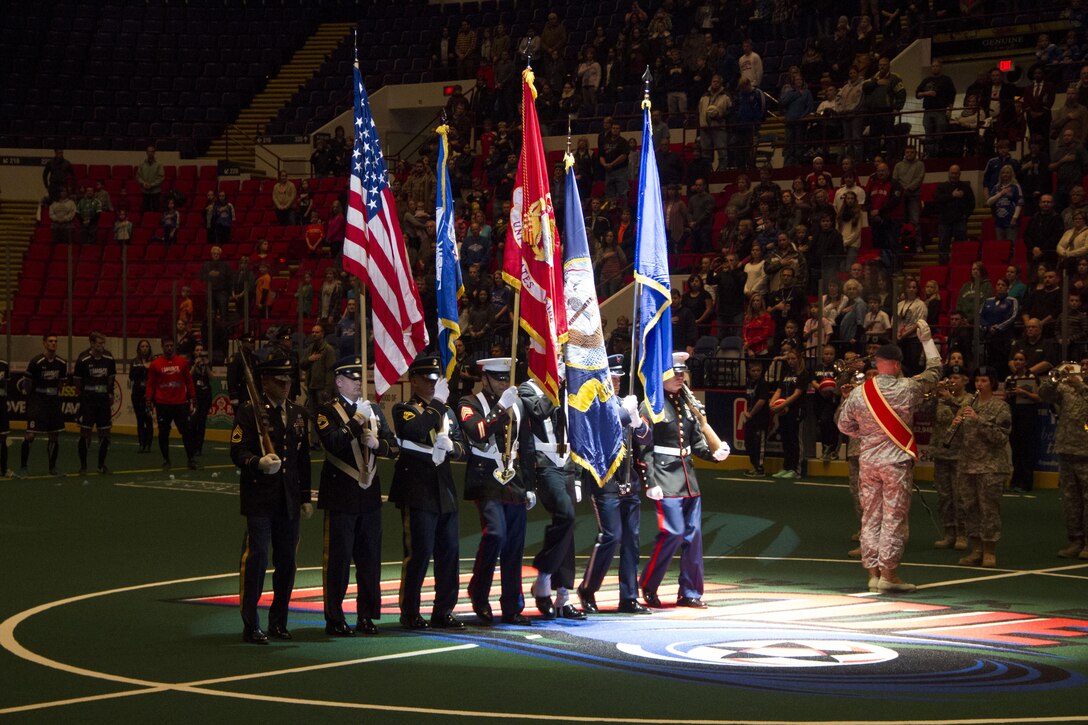 Sgts. Deon Craft and Nathan Krohn, Marines with Recruiting Station Milwaukee, march on the colors alongside the Army, Navy and Air Force, during the Milwaukee Wave opening home game Dec. 7, 2013. The Milwaukee wave designated the home opener as a “Military Appreciation Game,” taking a moment of silence for those lost at Pearl Harbor on Dec. 7, 1941.