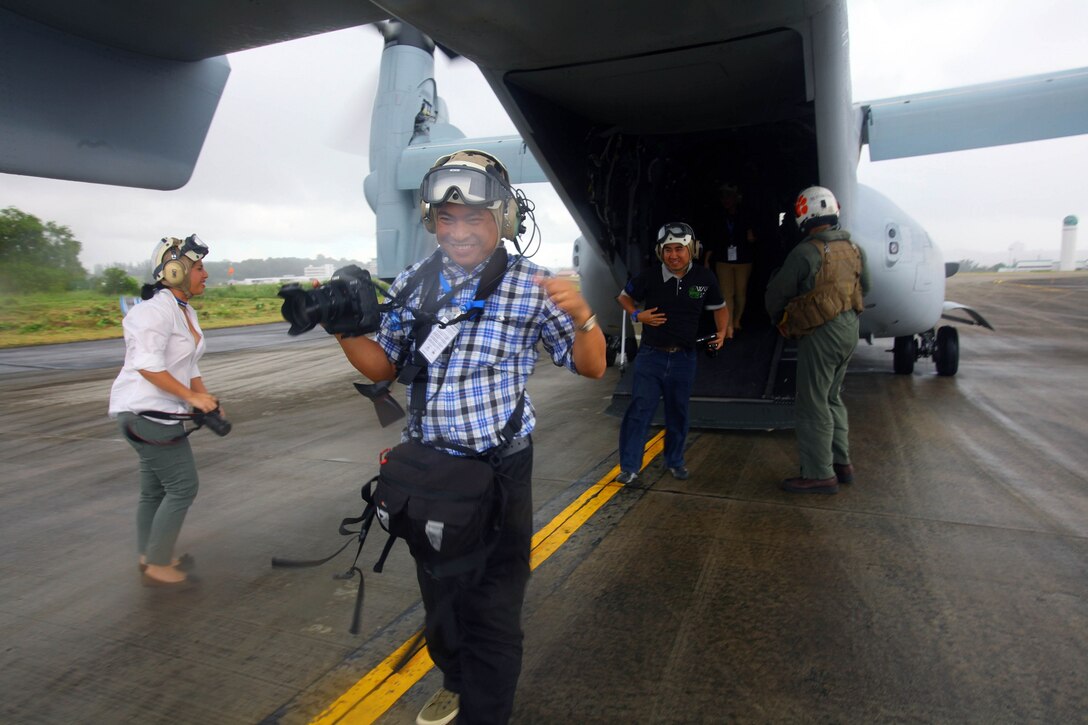 Brunei media walk off a U.S. Marine Corps MV-22B Osprey after taking a demonstration flight Dec. 5 at Rimba Air Base, Brunei, during the 4th biennial Brunei Darussalam International Defense Exhibition and Conference. Government organizations and various companies at BRIDEX 13 represented approximately 70 countries. The five-day event includes displays and demonstrations of military equipment, with the theme of bridging the capability gap. BRIDEX 13 is an opportunity for communication and cooperation with regional partners and allies, builds strong multilateral relationships and enhances preparedness for disasters and other contingency operations. U.S. participation in BRIDEX 13 demonstrates cooperative engagement with Brunei and continued commitment to regional security and stability in the Asia-Pacific region. The Osprey is assigned to Marine Medium Tiltrotor Squadron 262, Marine Aircraft Group 36, 1st Marine Air Wing, III Marine Expeditionary Force. (U.S. Marine Corps photo by Cpl. Alyssa Gunton/Released)