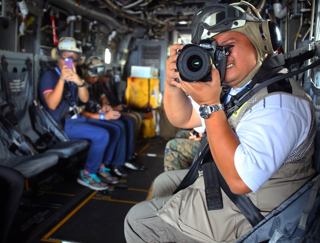 Brunei media photograph their first flight on a U.S. Marine Corps MV-22B Osprey Dec. 5 at Rimba Air Base, Brunei, during the 4th biennial Brunei Darussalam International Defense Exhibition and Conference. Government organizations and various companies at BRIDEX 13 represented approximately 70 countries. The five-day event includes displays and demonstrations of military equipment, with the theme of bridging the capability gap. BRIDEX 13 is an opportunity for communication and cooperation with regional partners and allies, builds strong multilateral relationships and enhances preparedness for disasters and other contingency operations. U.S. participation in BRIDEX 13 demonstrates cooperative engagement with Brunei and continued commitment to regional security and stability in the Asia-Pacific region. The Osprey is assigned to Marine Medium Tiltrotor Squadron 262, Marine Aircraft Group 36, 1st Marine Air Wing, III Marine Expeditionary Force. (U.S. Marine Corps photo by Cpl. Alyssa Gunton/Released)