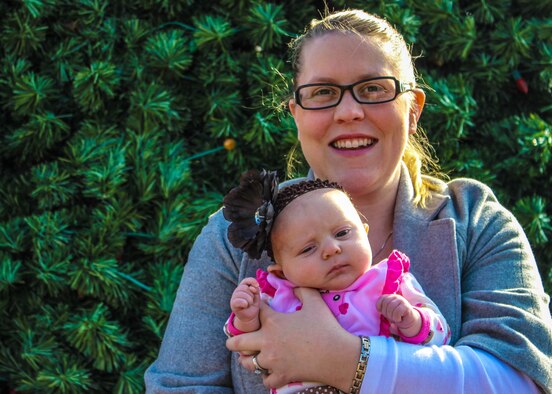 Allison Hermanson, wife of 1st Lt. Kyle Hermanson, 6th Battalion, 52nd Artillery Regiment, poses with her daughter Amelia in front of the base Christmas Tree at Osan Air Base, Republic of Korea. Hermanson completed her emergency medical technician certification, required every two years for an EMT, before her daughter was two months old. (U.S. Army photo/Spc. Stephanie Clements)