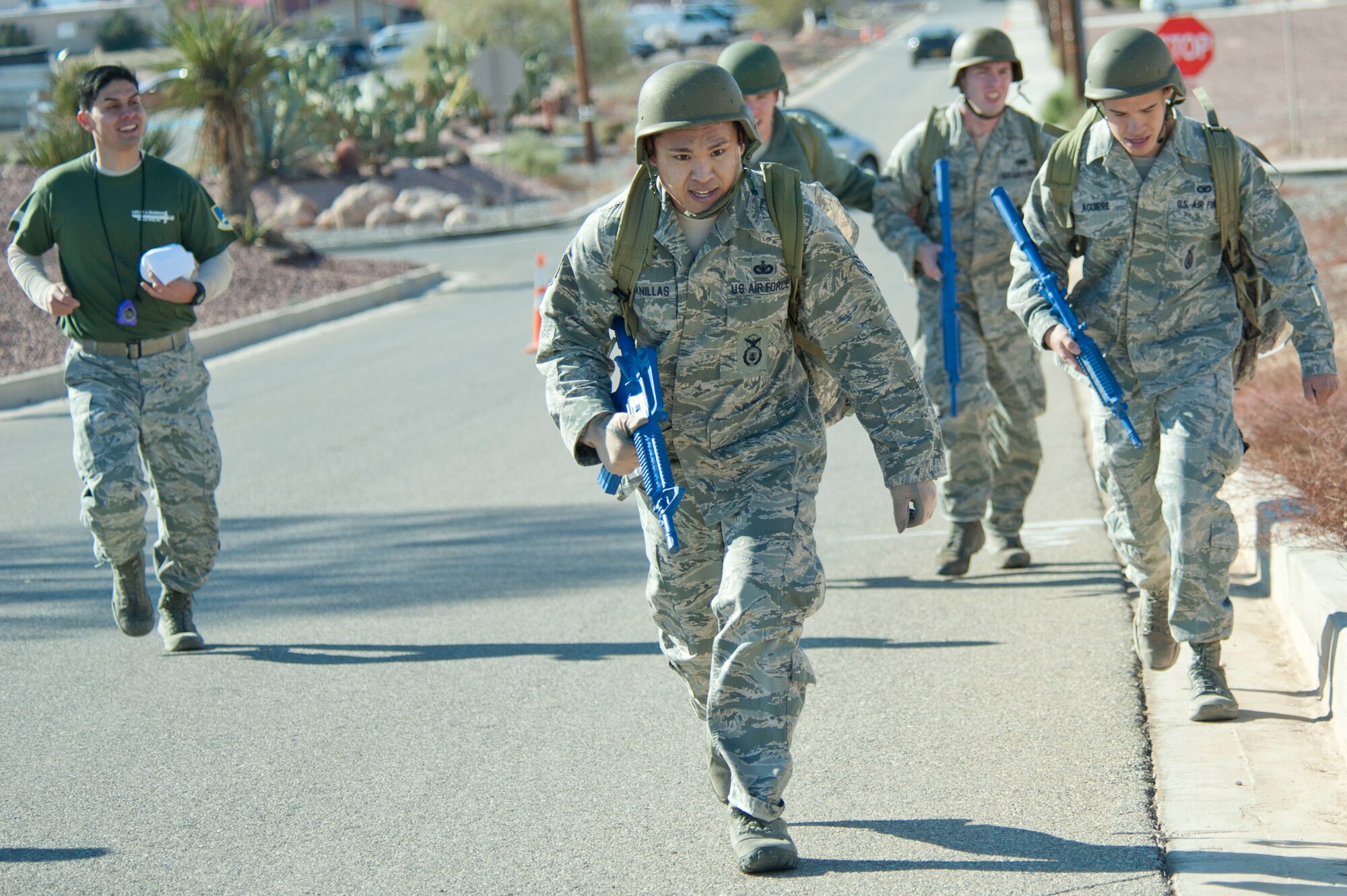 Airmen from the 99th Security Forces Squadron complete the last yards of a half-mile ruck march during the 99th SFS Warrior Challenge event Dec. 6, 2013, at Nellis Air Force Base, Nev. Each team was scored by the completion time of their half-mile ruck march. Each team is assigned an escort to follow along monitoring the teams in case any medical issues arise. (U.S. Air Force photo by Airman 1st Class Timothy Young)