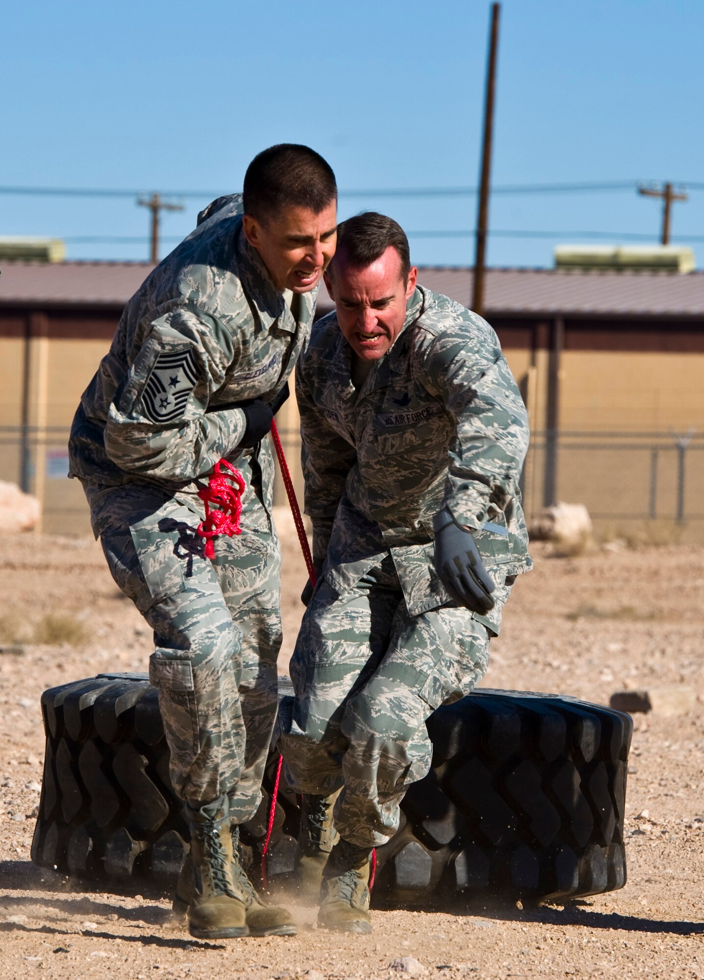 U.S. Air Force Chief Master Sgt. Steven Cleveland, 99th Air Base Wing command chief, and Col. Robert Ramsden, 99th ABW vice commander, drag a tire during the 99th Security Forces Squadron Warrior Challenge Dec. 6, 2013, at Nellis Air Force Base, Nev. The challenge course tested a team's physical, mental and teamwork ability. (U.S. Air Force photo by Airman 1st Class Christopher Tam)