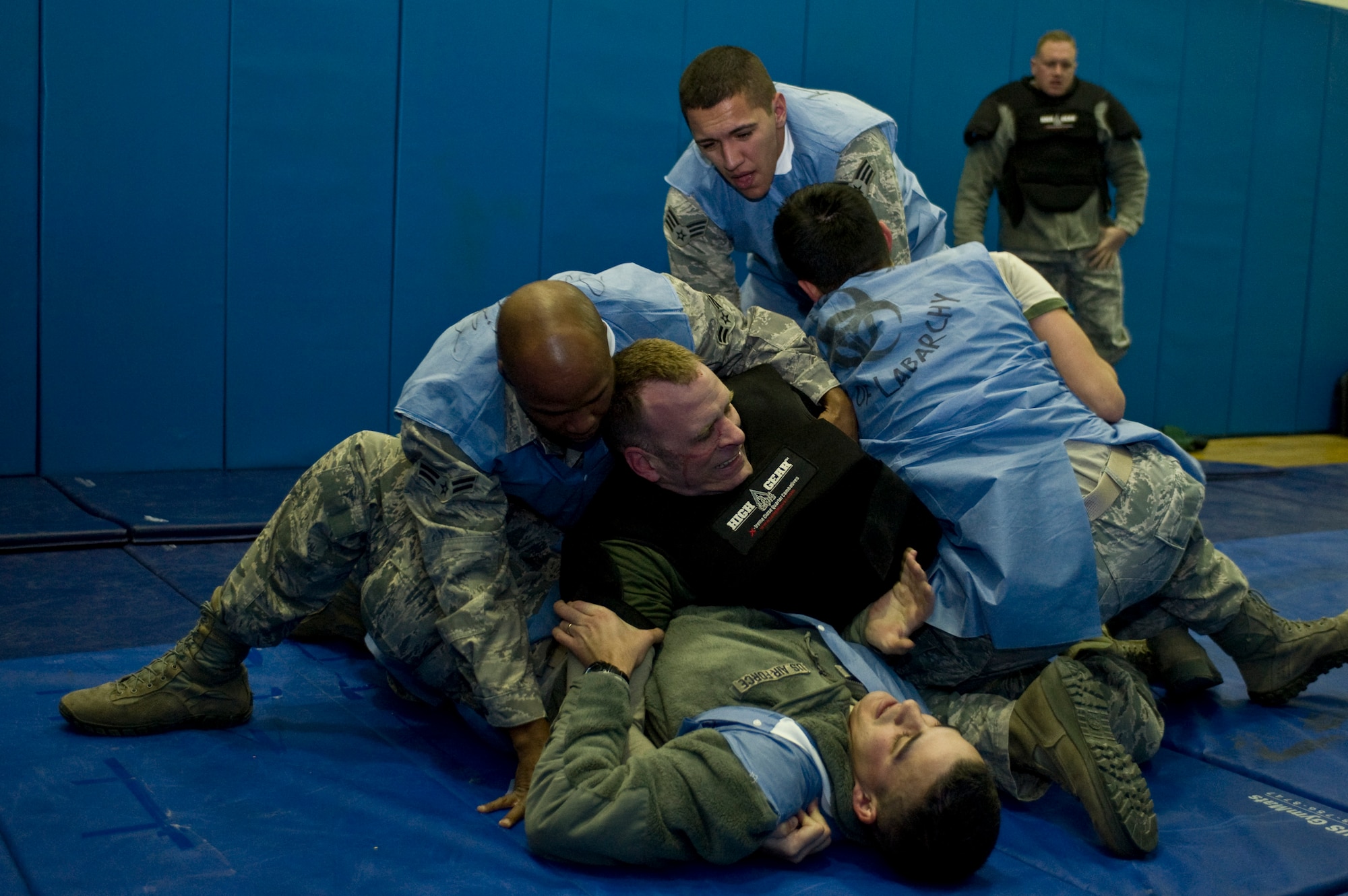The Sons of Labarchy team from the 99th Medical Support Squadron attempt to disable a 99th Security Forces Squadron member in Red Man training pads during the 99th SFS Warrior Challenge Dec. 6, 2013, at Nellis Air Force Base, Nev. During this challenge, teams had a 3 minute limit to disable two opponents. (U.S. Air Force photo by Senior Airman Matthew Lancaster)