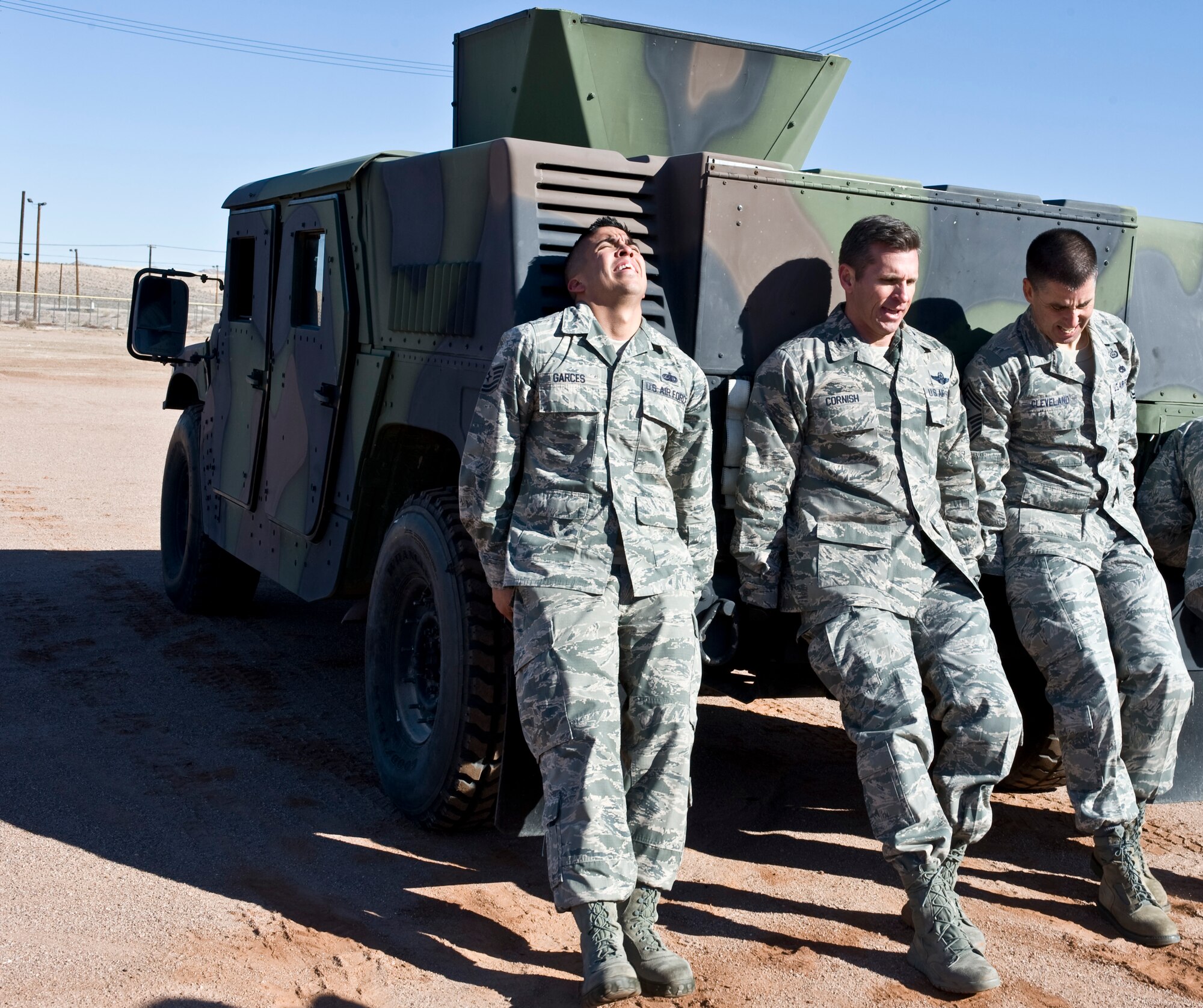 From left to right, Tech Sgt. Kevin Garces 99th Air Base Wing command chief master sergeant executive assistant, Col. Barry Cornish, 99th ABW commander, and Chief Master Sgt. Steven Cleveland, 99th ABW command chief master sergeant, push a HMMWV during the 99th Security Forces Squadron Warrior Challenge Dec. 6, 2013, at Nellis Air Force Base, Nev. The course consisted of seven stations that tested teams mentally and physically. (U.S. Air Force photo by Senior Airman Matthew Lancaster)