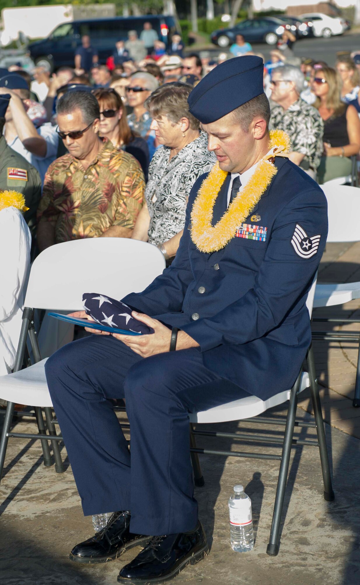 Tech. Sgt. Andrew Shepherd, right, 15th Aircraft Maintenance Squadron, stares fondly at the folded flag and certificate he received at the December 7th Remembrance Ceremony at Hickam Field, Dec. 7, 2013. Shepherd was joined by four December 7th attack survivors and family members of the deceased who were honored at the 72nd anniversary ceremony here. Shepherd is the grandson of Hickam Field attack, and Battle of Midway survivor Marion Shepherd. (U.S. Air Force photo/Staff Sgt. Terri Paden)