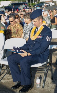 Tech. Sgt. Andrew Shepherd, right, 15th Aircraft Maintenance Squadron, stares fondly at the folded flag and certificate he received at the December 7th Remembrance Ceremony at Hickam Field, Dec. 7, 2013. Shepherd was joined by four December 7th attack survivors and family members of the deceased who were honored at the 72nd anniversary ceremony here. Shepherd is the grandson of Hickam Field attack, and Battle of Midway survivor Marion Shepherd. (U.S. Air Force photo/Staff Sgt. Terri Paden)