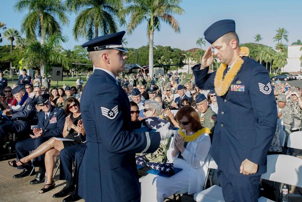 Tech. Sgt. Andrew Shepherd, right, 15th Aircraft Maintenance Squadron, renders a salute before being presented a flag by a Hickam Honor Guard member during the December 7th Remembrance Ceremony at Hickam Field, Dec. 7, 2013. Shepherd is the grandson of Hickam Field Attack survivor, Marion Shepherd, and received the flag in honor and recognition of his grandfather’s selfless service. Shepherd has been assigned to Hickam since August 2013 and served as a volunteer and honored guest at a Dec. 7, 1941, remembrance ceremony which paid homage to the 190 fallen Airmen and civilians, as well as the survivors.  (U.S. Air Force photo/Staff Sgt. Terri Paden)