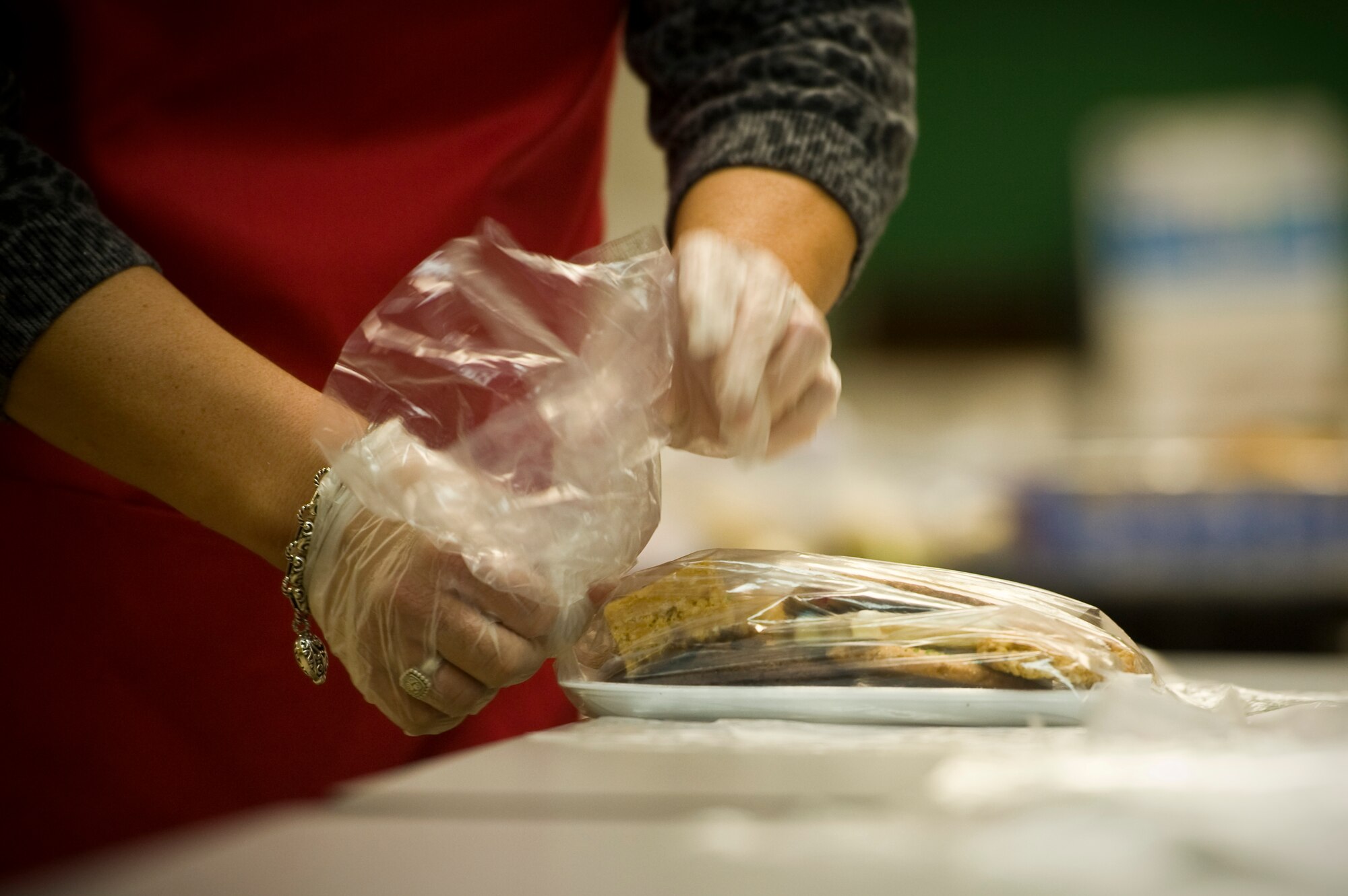 Vanessa Cleveland, wife of U.S. Air Force Chief Master Sgt. Steven Cleveland, 99th Air Base Wing command chief, wraps a bag of cookies during the annual Cookie Drive at the chapel Dec. 9, 2013, at Nellis Air Force Base, Nev. Thirty volunteers accepted drop-off donations, assembled and bagged cookies that were donated from the local community. The whole event took about four hours and was delivered by first sergeants to the dorms soon after they were packaged. (U.S. Air Force photo by Airman 1st Class Christopher Tam)