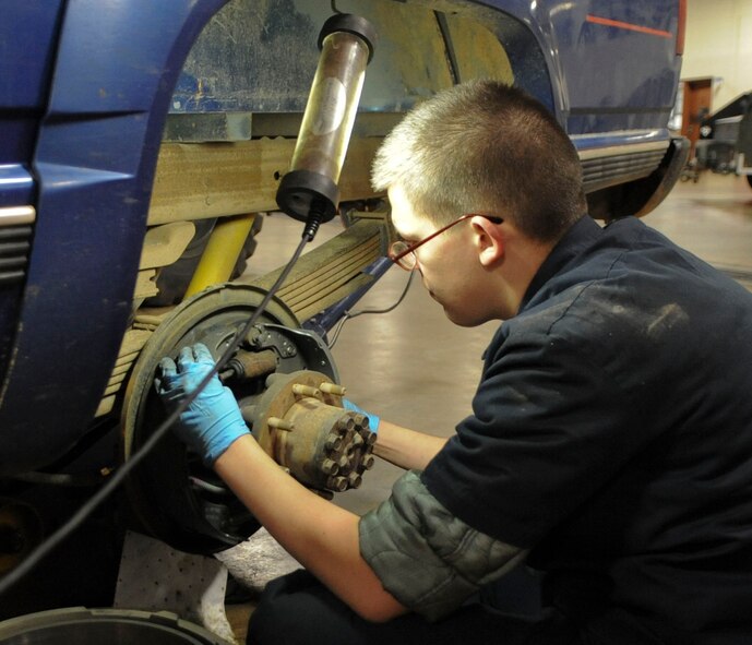 Airman 1st Class Daniel Ward, 2nd Logistics Readiness Squadron vehicle maintenance technician, reattaches a retaining spring for rear brakes of a truck on Barksdale Air Force Base, La., Dec. 10, 2013. The vehicle maintenance section on Barksdale is responsible for repairing and conducting regular checks on a fleet worth more than $40 million. (U.S. Air Force photo/Senior Airman Kristin High)