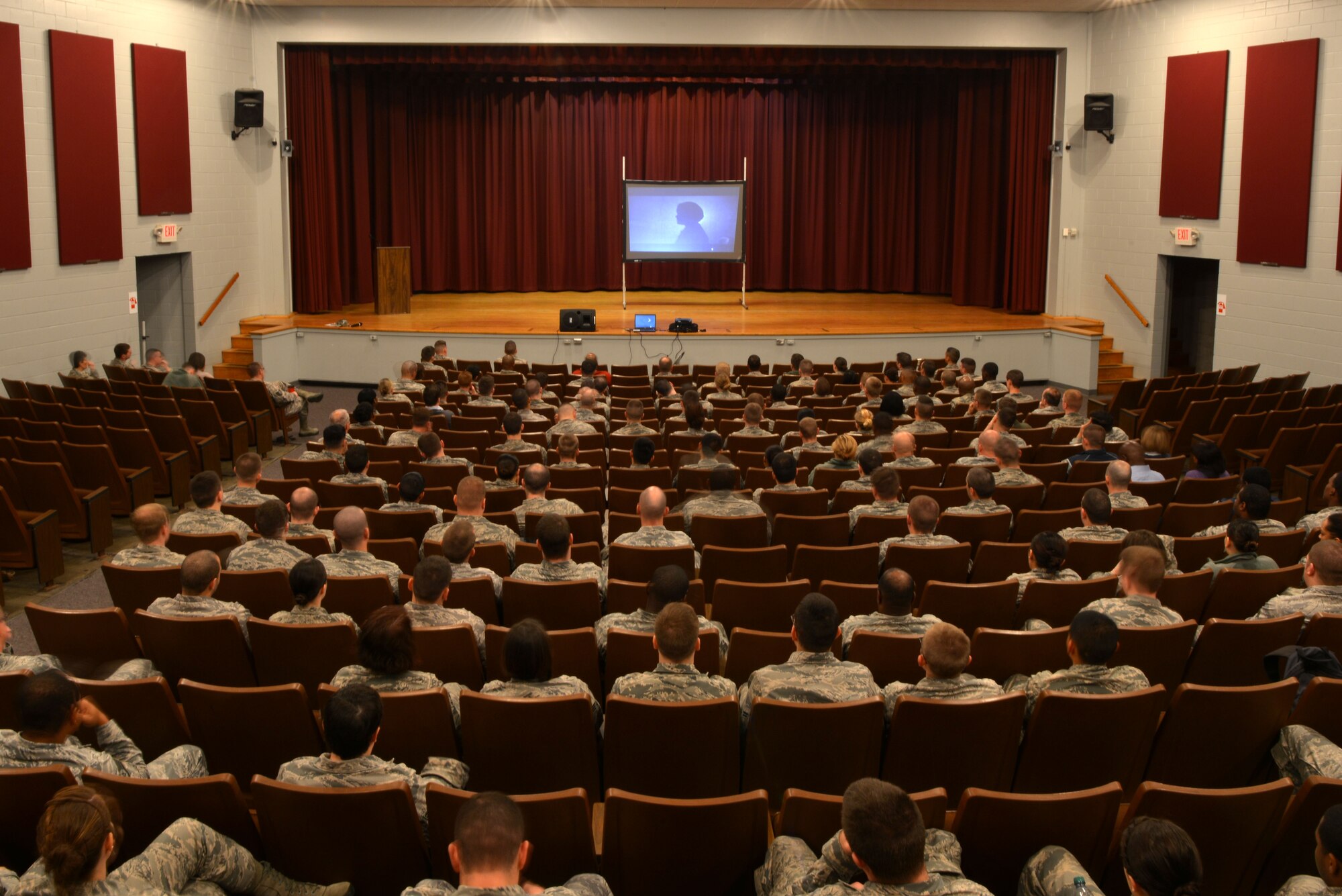 U.S. Air Force Airmen sit in the base theater during a Comprehensive Airmen Fitness week briefing, Shaw Air Force Base, S.C., Dec. 2, 2013. Airmen listened to testimonies and watched videos of hardship and resiliency before breaking out into small groups to talk about spirituality. (U.S. Air Force photo by Airman 1st Class Jensen Stidham/Released) 