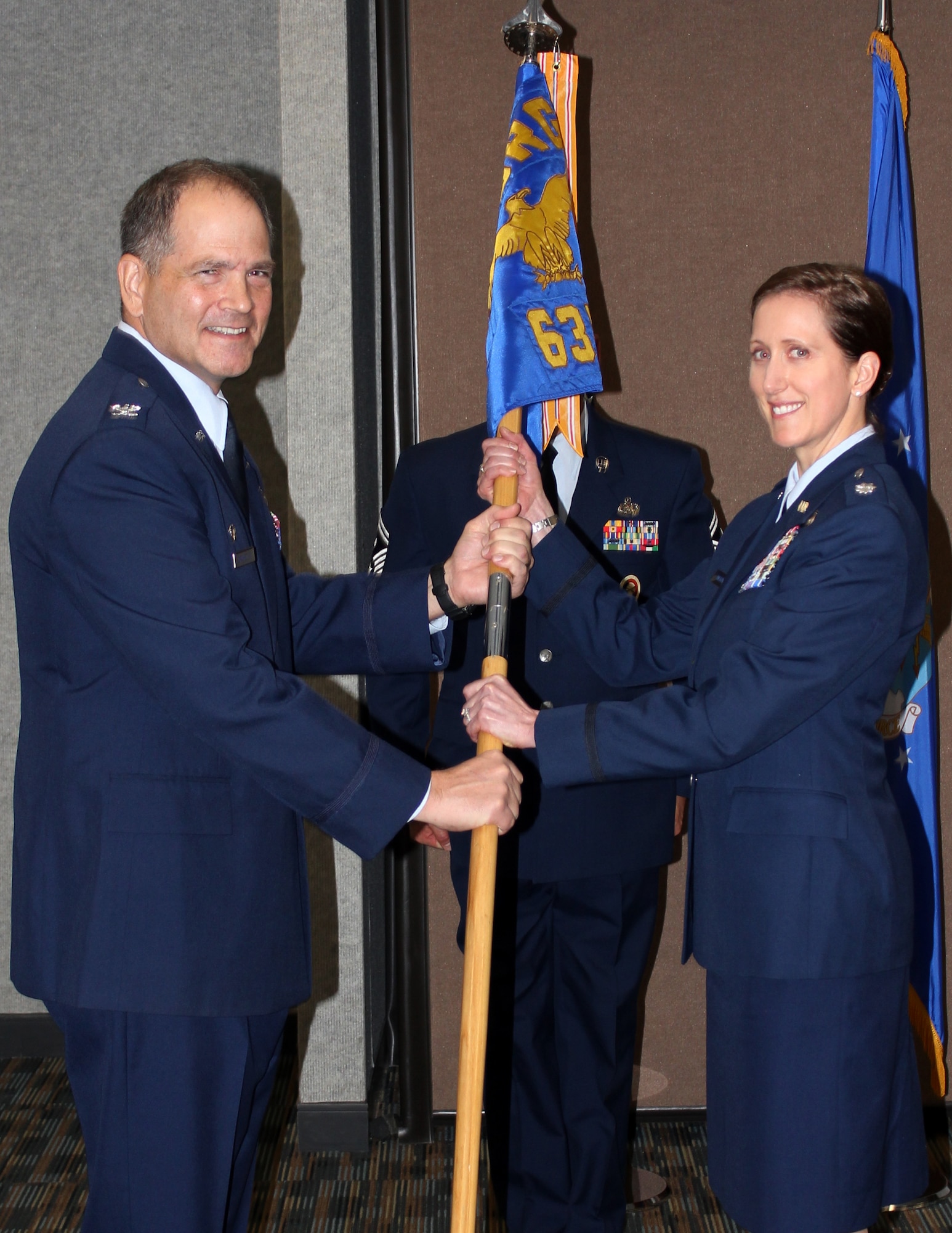 U.S. Air Force Col. Douglas Drakeley, 655th Intelligence Surveillance and Reconnaissance Group commander, presents the squadron guidon to Lt. Col. Jaime McGown, 63rd Intelligence Squadron commander, during an activation ceremony at Langley Air Force Base, Va., Dec. 6, 2013. The 63rd IS reports to the 480th ISR Wing and 497th ISR Group, who operate the Distributed Ground Station – One. (U.S. Air Force courtesy photo/Released)