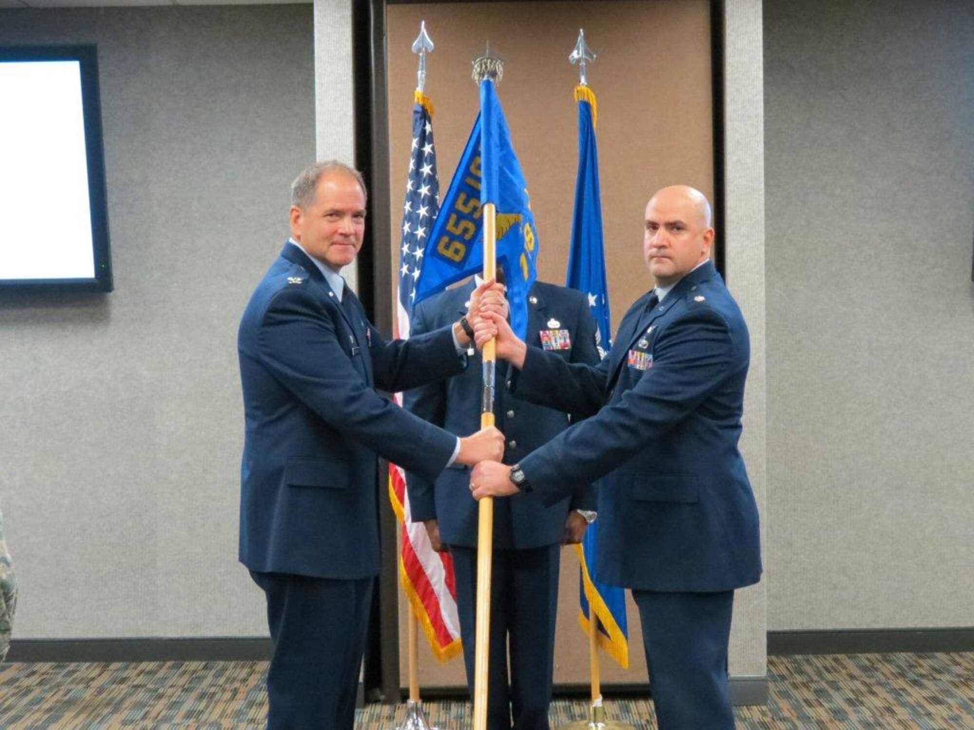 U.S Air Force Col. Douglas Drakeley, 655th Intelligence Surveillance and Reconnaissance Group commander, passes the squadron guidon to Lt. Col. Joshua Redden, 718th Intelligence Squadron commander, during an assumption of command ceremony at Langley Air Force Base, Va., Dec. 6, 2013. The mission of the 718th IS is to provide combat mission-ready intelligence, surveillance and reconnaissance command and control, signal intelligence mission management and all-source analysts who process, exploit and disseminate ISR data, in support of the Distributed Common Ground System weapon system and combatant commanders. (U.S. Air Force courtesy photo/Released)