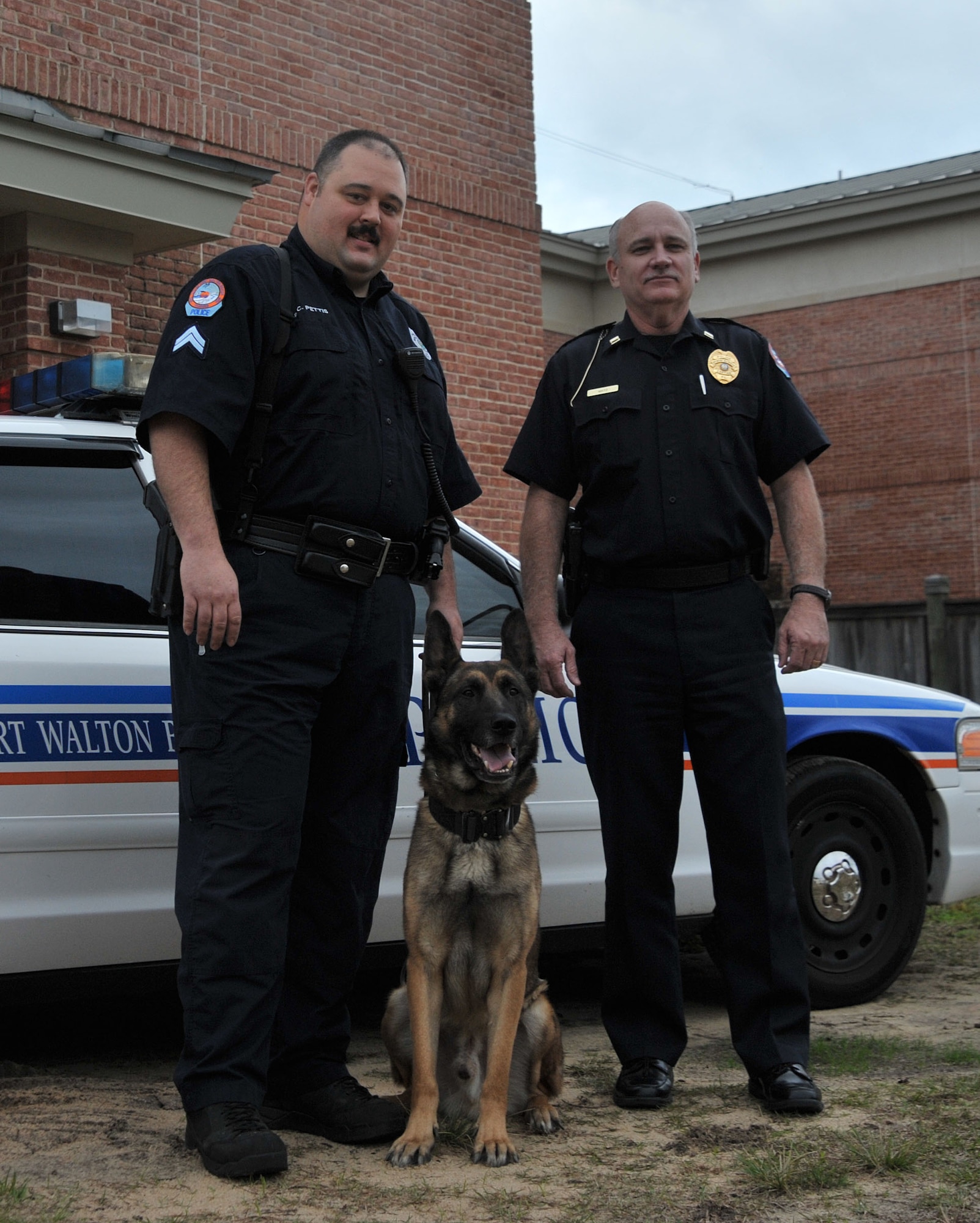 Fort Walton Beach police Cpl. Charles Pettis and police Capt. Tom Mhez pose with Astro the narcotic detection dog at the police department in Fort Walton Beach, Fla., Dec. 9, 2013. The military donated Astro, formally known as Astor, to the FWB Police Department in April of 2011. (US Air Force Photo/Airman 1st Class Andrea Posey)