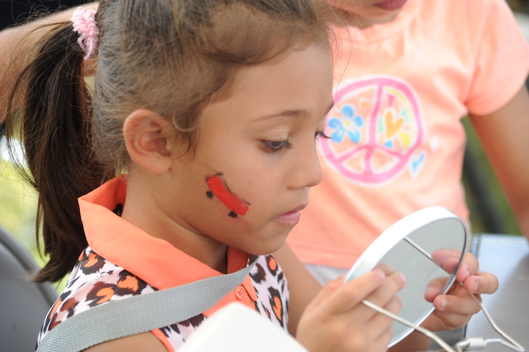A young girl admires her face paint during Joint Task Force-Bravo's "Operation Holiday Blessing," at Soto Cano Air Base, Honduras, Dec. 6, 2013. More than 300 Honduran orphans were treated to a day of activities, gifts, and holiday joy, provided by more than 200 volunteers from the Task Force. (Photo by Martin Chahin)