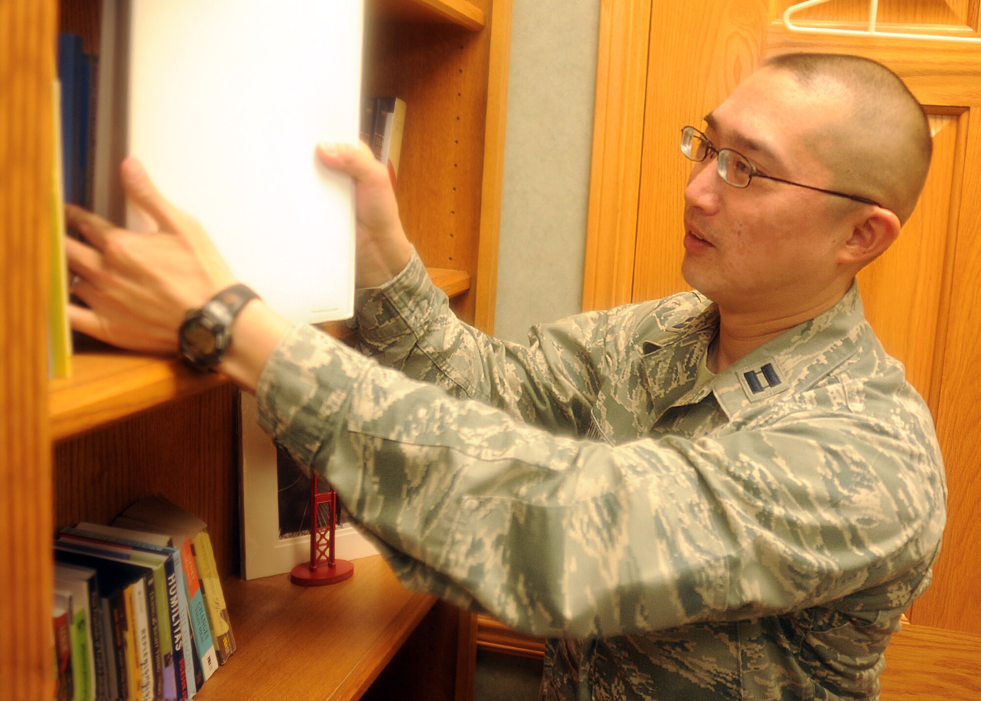 Capt. (Ch.) Asa Chung, 22nd Air Refueling Wing Protestant Chaplain, puts a book on a shelf at the base chapel at McConnell Air Force Base, Kan., Dec. 4, 2013. He was selected as the 22nd ARW spotlight performer for the week of Dec. 2 to 6. (U.S. Air Force photo/Senior Airman Maurice A. Hodges)