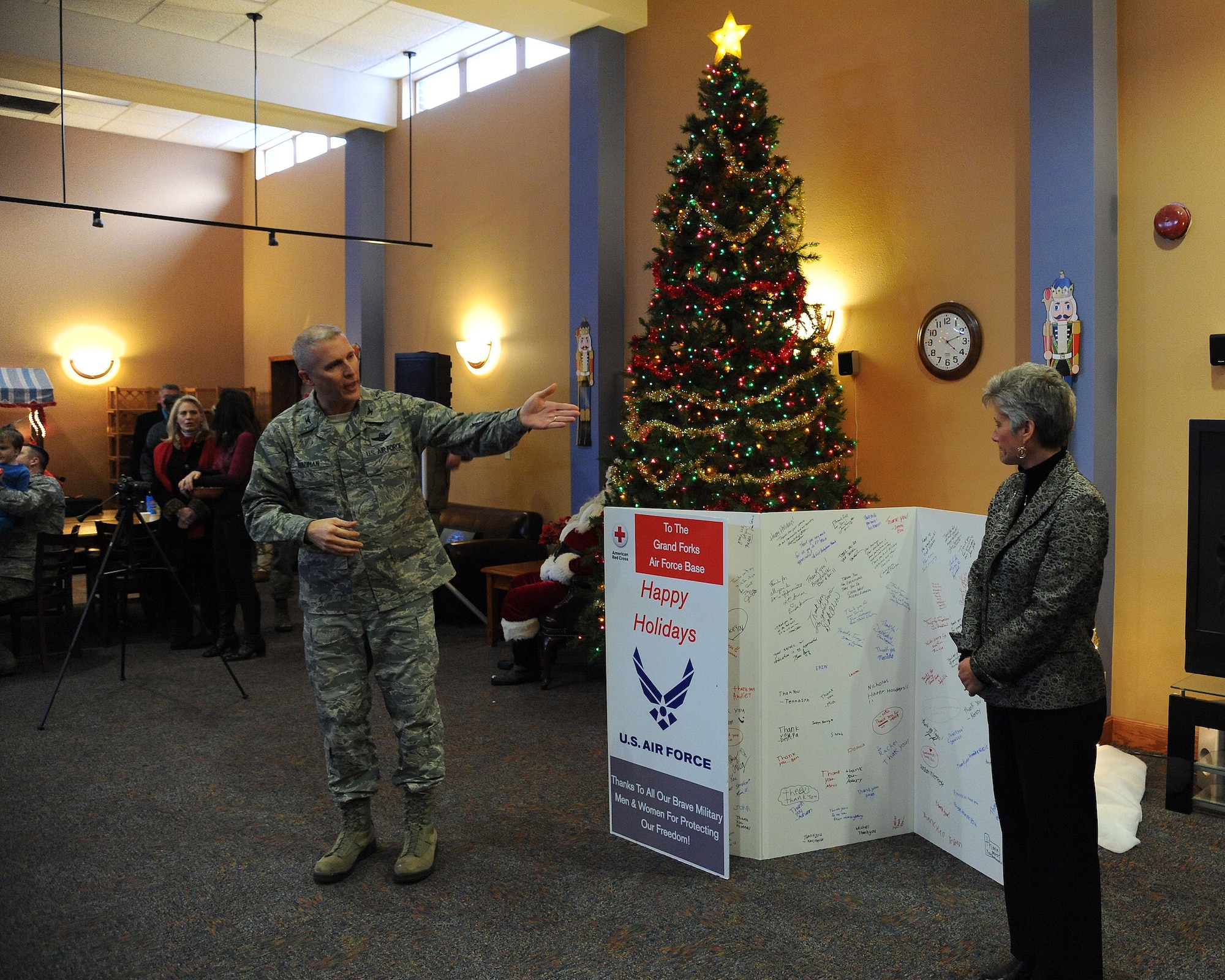 Judy Green, American Red Cross Regional chief executive officer, presents Col. Paul Bauman, 319th Air Base Wing commander, and the entire base with a community-signed holiday card of appreciation Dec. 5, 2013, on Grand Forks Air Force Base, N.D. The American Red Cross gave the card in appreciation to what servicemen and women do every day to protect the United States of America. (U.S. Air Force photo/Airman 1st Class Zachiah Roberson)