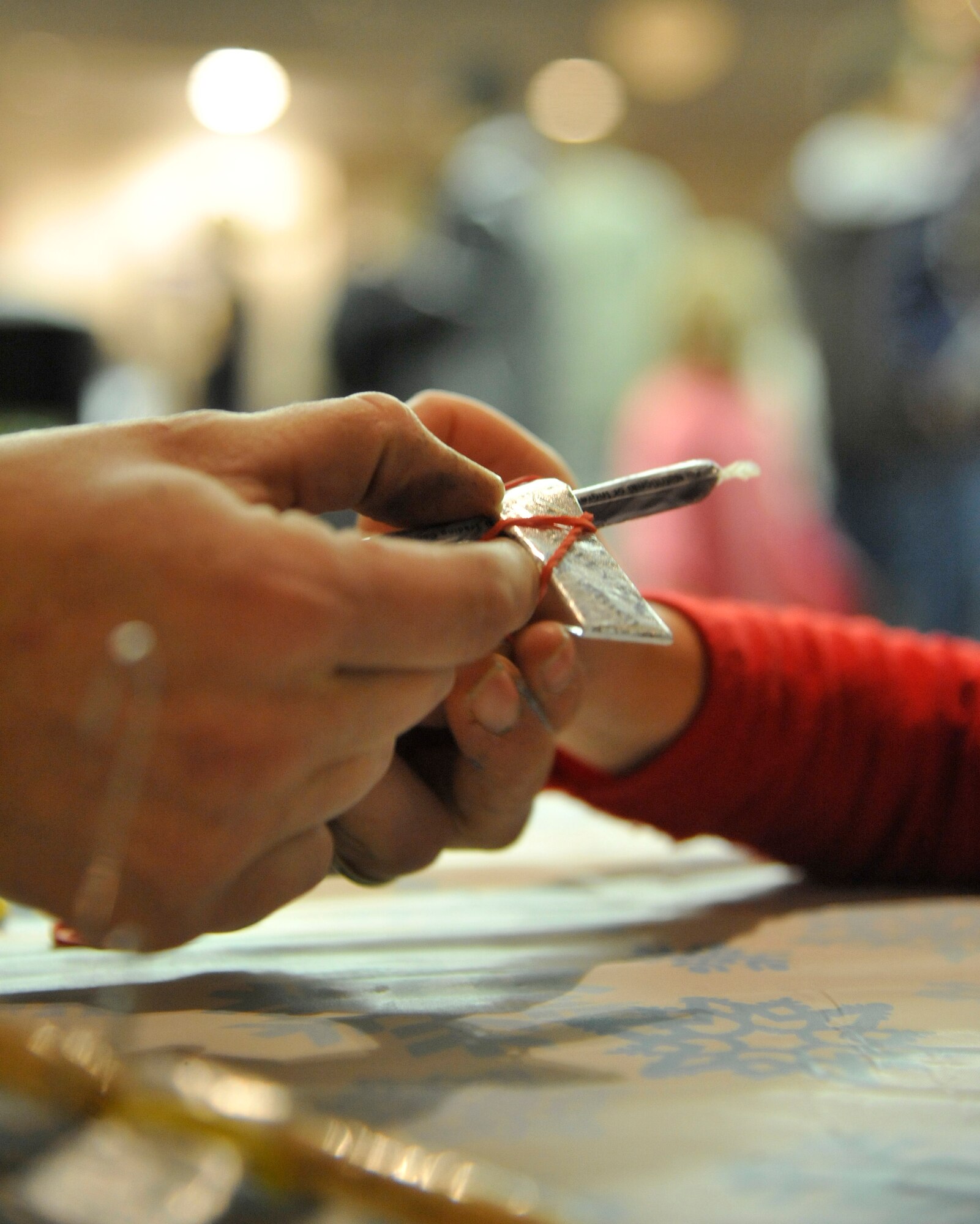 Lisa Gee, 509th Force Support Squadron child and youth programs assistant, gives a girl with a candy cane at Whiteman Air Force Base, Mo., Dec. 3, 2013. Arts and crafts were part of the celebration after the base tree and menorah lighting. (U.S. Air Force photo by Airman 1st Class Keenan Berry/Released)