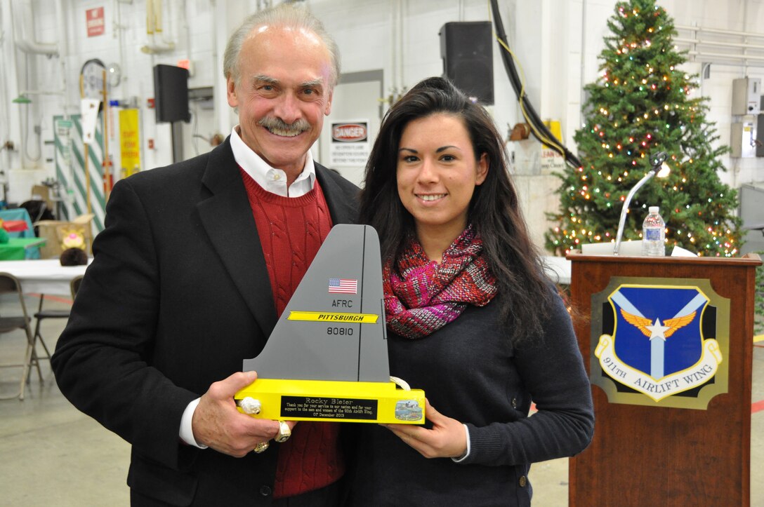 Former Pittsburgh Steelers running back, Rocky Bleier, receives a token of appreciation from the 911th Airlift Wing by way of Staff Sgt. Ashleylynn Wiley, an air reserve technician with the Structural Maintenance Squadron who helped make the memento, December 7, 2013, at the Pittsburgh International Airport Air Reserve Station. The four-time super bowl champion was a special guest at the 911th AW holiday party and delivered a speech about hope and persevering through tough times in order to accomplish goals. Bleier, a Vietnam veteran and recipient of the Purple Heart and Bronze Star, also signed autographs and posed for photos with Airmen and their families. (U.S. Air Force photo by Senior Airman Jonathan G. Hehnly)