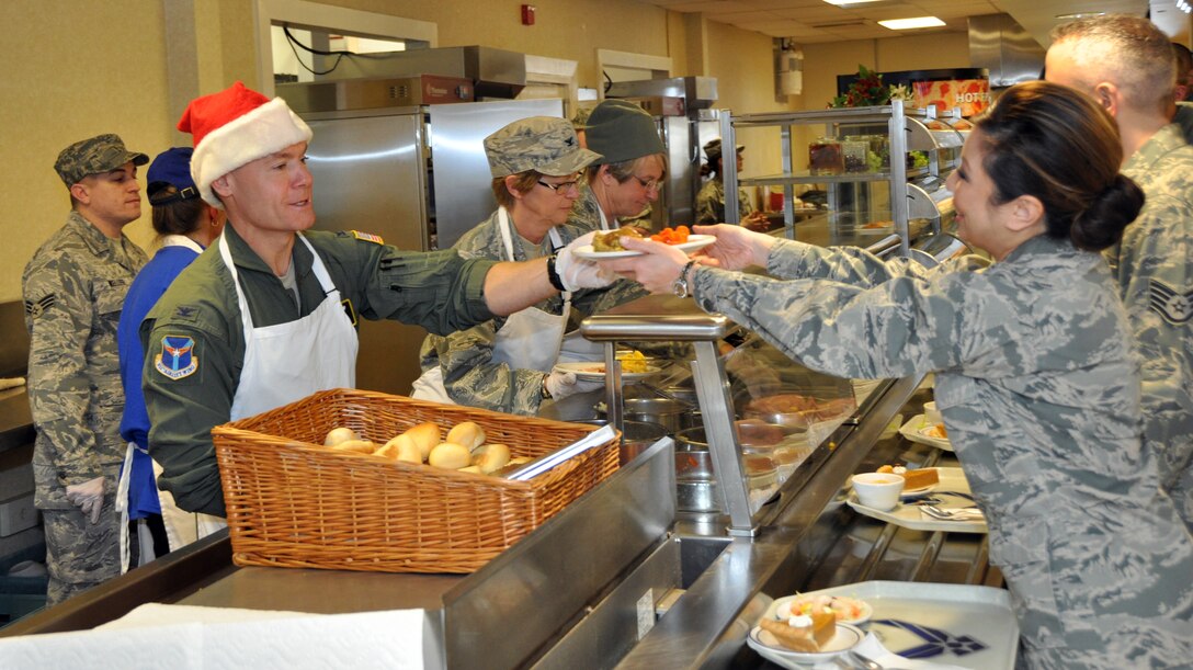 Col. Craig C. Peters, commander of the 911th Airlift Wing, serves the December holiday meal to Maj. Tina Burr, the chief optometrist with the Aeromedical Staging Squadron, Dec. 7, 2013, at the Pittsburgh International Airport Air Reserve Station. The holiday meal is a time for members of the wing to enjoy a lunch with their fellow Airmen, while leadership of the wing serves the food to show appreciation for the hard work performed all year long.  (U.S. Air Force photo by Senior Airman Joseph E. Bridge) 