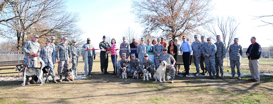U.S. Air Force Brig. Gen. Thomas Bussiere, 509th Bomb Wing commander, and Mandy Barker, wife of Airman 1st Class Alex Barker from the 509th Civil Engineer Squadron, celebrate the ribbon-cutting for the new Whiteman Dog Park Dec. 3, 2013, at Whiteman Air Force Base, Mo. The park is open from dusk till dawn. (U.S. Air Force photo by Staff Sgt. Brigitte N. Brantley/Released)
