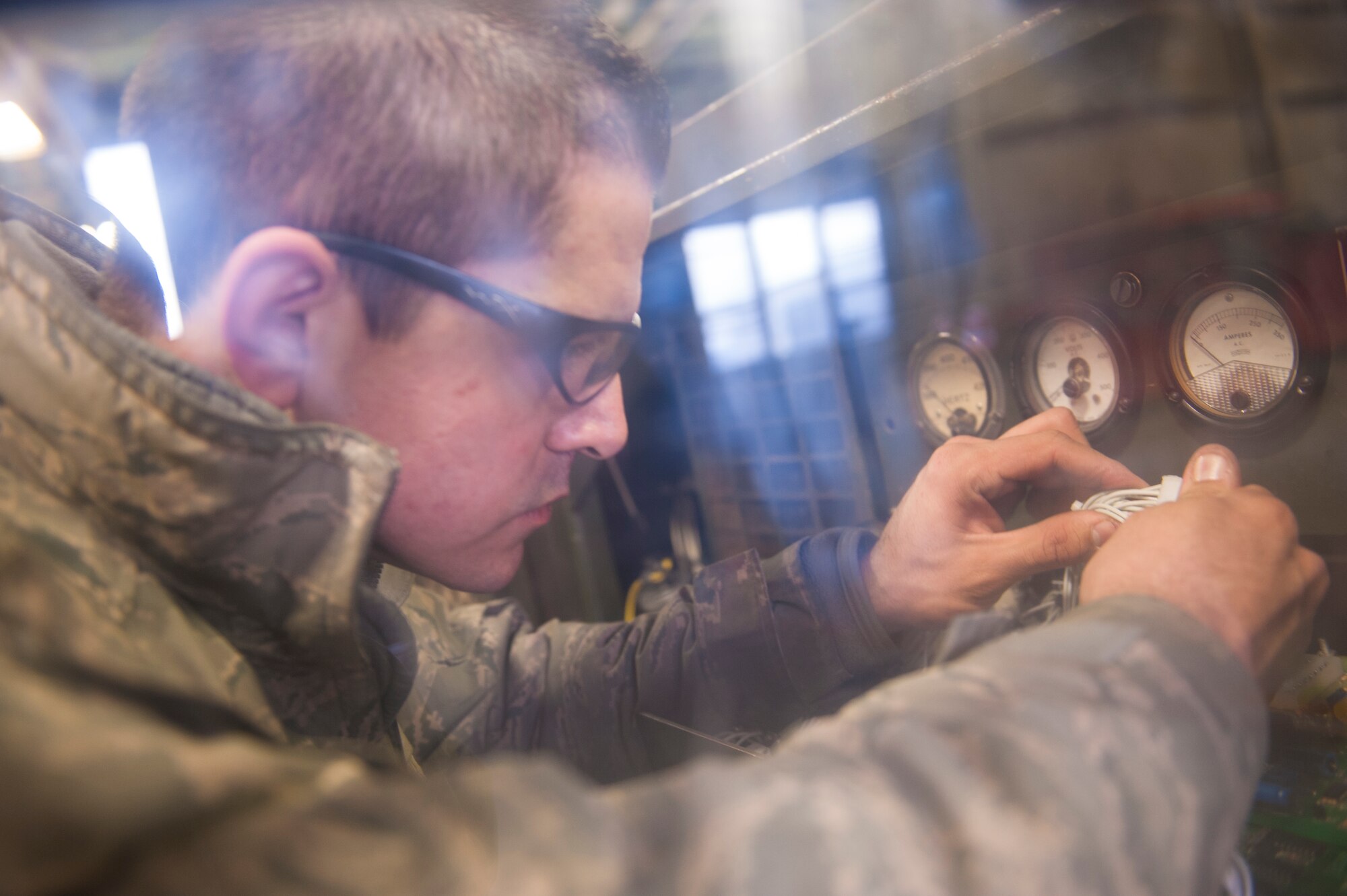 Senior Airman Darrell Ochoa, 5th Maintenance Squadron aerospace ground equipment mechanic, works on wiring on a piece of equipment used to perform aircraft maintenance at Minot Air Force Base, N.D., Dec. 5, 2013. AGE Airmen repair and maintain all the ground equipment that is used to ensure the B-52H Stratofortresses are prepared for flight. (U.S. Air Force photo/Airman 1st Class Apryl Hall)