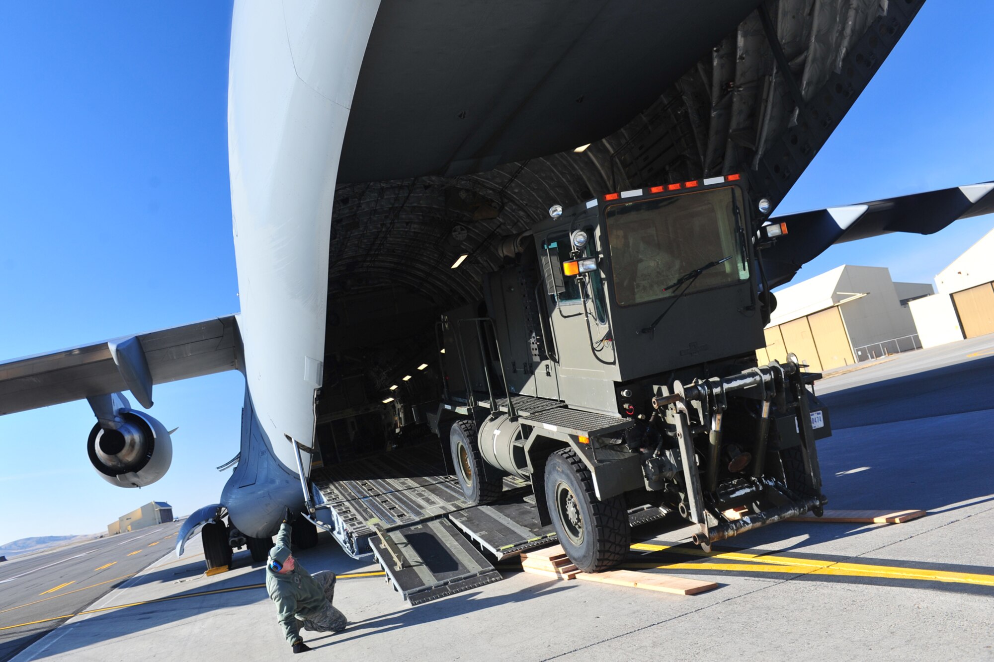 Airmen with the 92nd Logistics Readiness Squadron load a 19-ton snow blowing vehicle into a C-17 Globemaster III at Fairchild Air Force Base, Wash., Dec. 4, 2013. The C-17 crew will be offloading the vehicle at the Transit Center at Manas, Kyrgyzstan, in preparation for the incoming weather. (U.S. Air Force photo by Senior Airman Taylor Curry/Released)