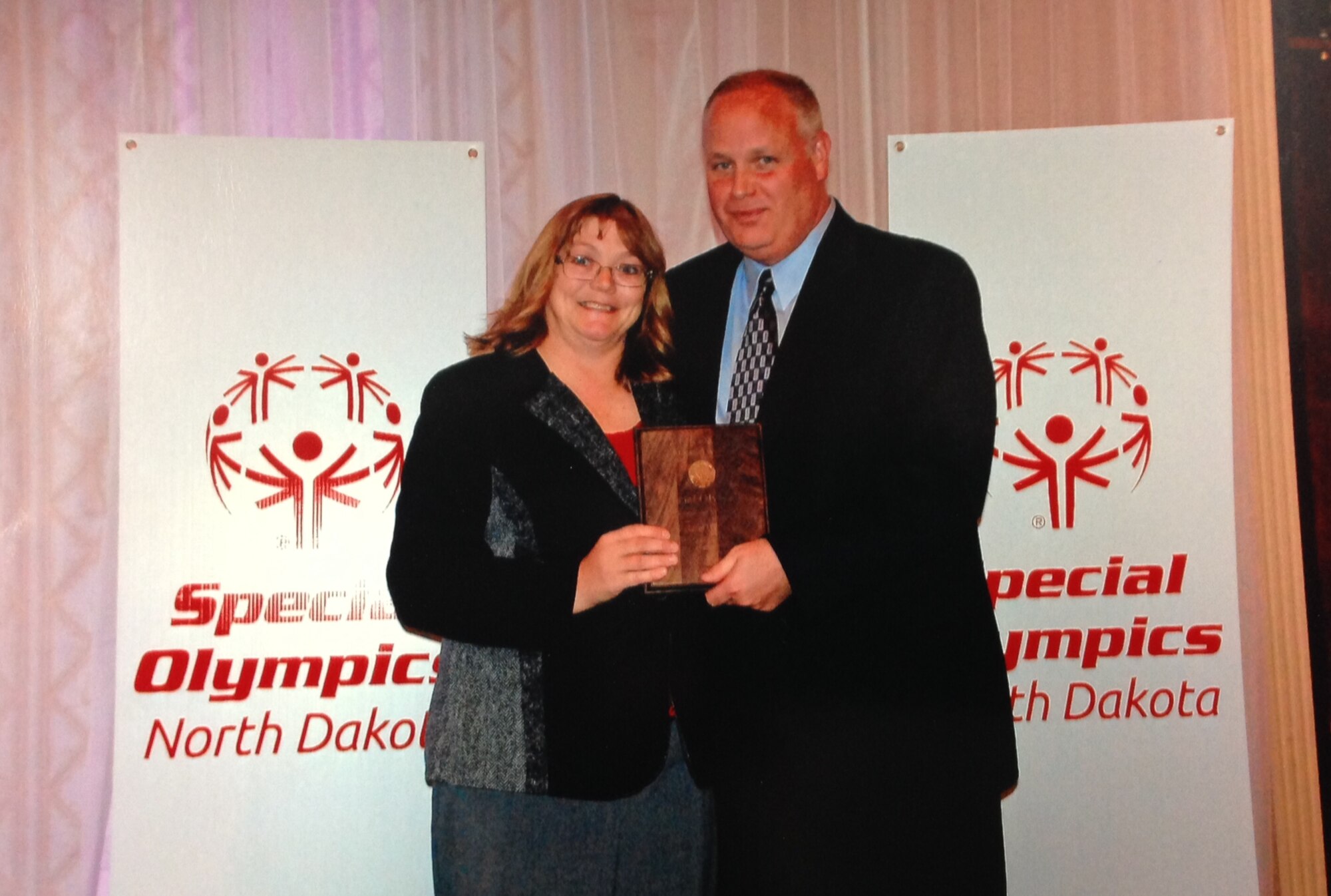 Janet Wing, 5th Logistics Readiness Squadron chief of readiness, is awarded the Special Olympics Outstanding State Volunteer Award for the state of North Dakota, Nov. 16, 2013. This is Wing’s first win, having been nominated for the award twice. She has been involved in Special Olympics for more than 18 years. (Courtesy photo)