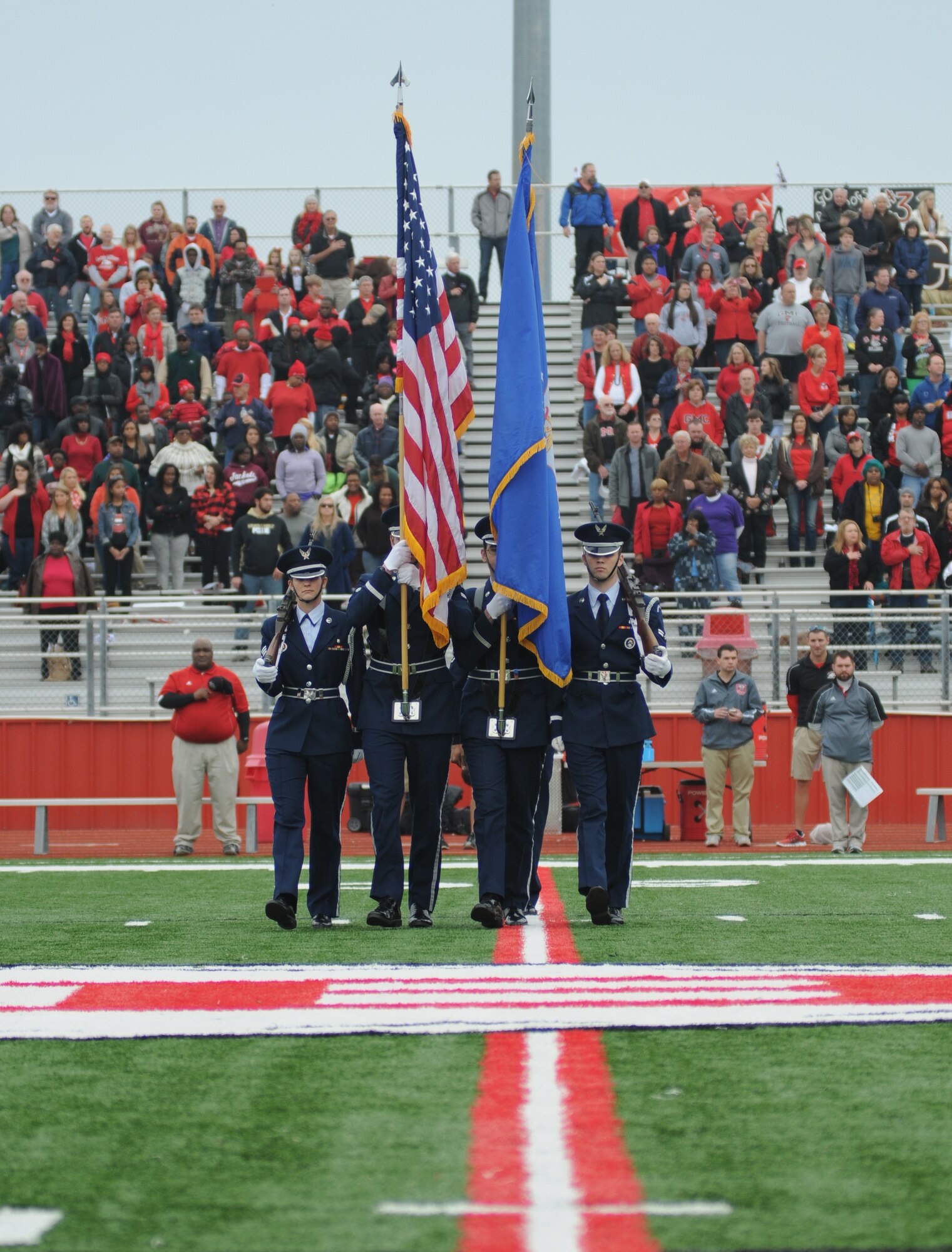 The Honor Guard from Keesler Air Force Base, Miss., march onto the field in preparation of presenting the colors for the singing of the Nation Anthem during a pre-game celebration at the 2013 Mississippi Bowl at the Biloxi High School football stadium Dec. 8, 2013. Brig. Gen. Patrick Higby, 81st Training Wing commander, and Airmen carrying the 50-State flags also participated in the pre-game celebration.  (U.S. Air Force photo by Kemberly Groue)