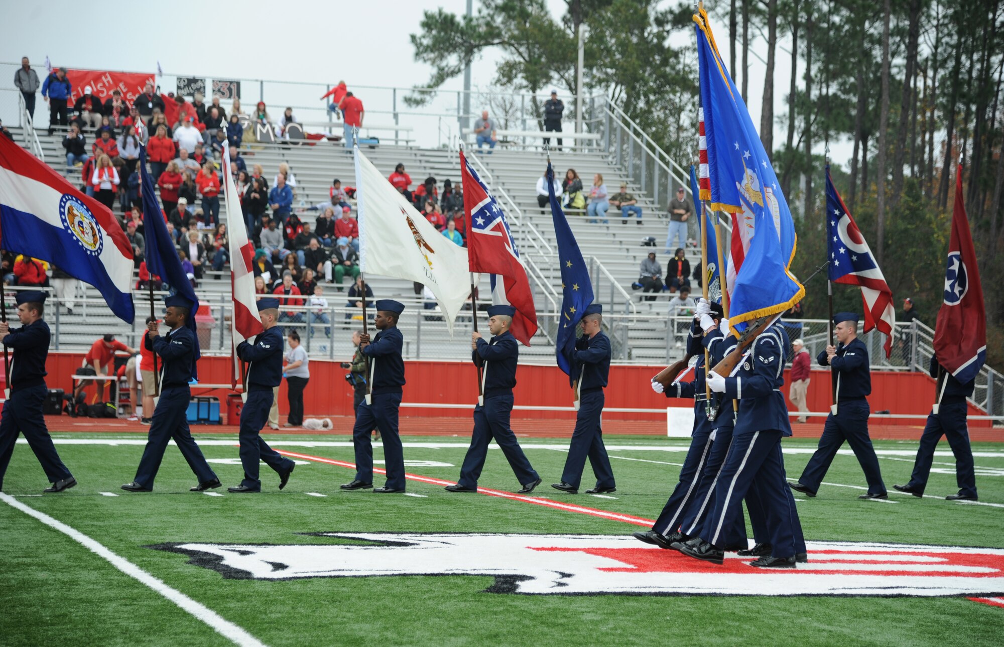 The Honor Guard and Airmen carrying the 50-State flags from Keesler Air Force Base, Miss., exit the field after participated during a pre-game celebration at the 2013 Mississippi Bowl at the Biloxi High School football stadium Dec. 8, 2013. Brig. Gen. Patrick Higby, 81st Training Wing commander, participated in the coin toss of the pre-game celebration.  (U.S. Air Force photo by Kemberly Groue)
