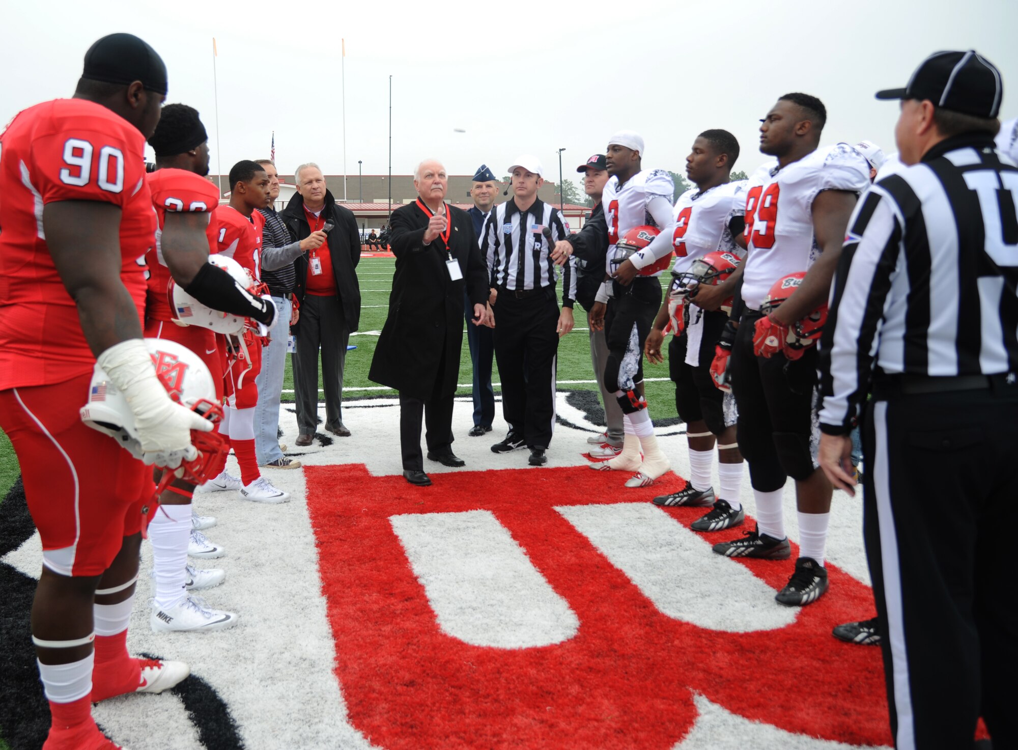 Dub Herring, Title sponsor, flips the coin during the coin toss as Brig. Gen. Patrick Higby, 81st Training Wing commander, Keesler Air Force Base, Miss., stands behind him in view during a pre-game celebration at the 2013 Mississippi Bowl at the Biloxi High School football stadium Dec. 8, 2013. The Keesler Honor Guard and Airmen carrying the 50-State flags also participated in the pre-game celebration.  (U.S. Air Force photo by Kemberly Groue)