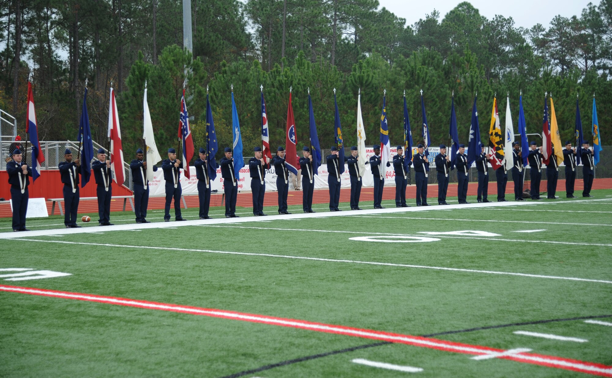 Airmen from Keesler Air Force Base, Miss., line the field while carrying the 50-State flags during a pre-game celebration at the 2013 Mississippi Bowl at the Biloxi High School football stadium Dec. 8, 2013. Brig. Gen. Patrick Higby, 81st Training Wing commander, and the Keesler Honor Guard also participated in the pre-game celebration.  (U.S. Air Force photo by Kemberly Groue)