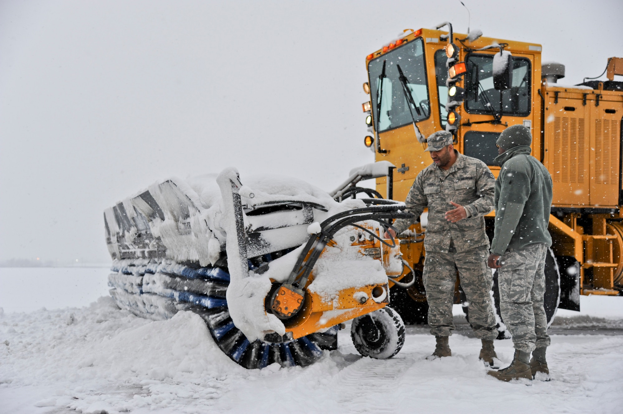 Staff Sgt. Tarrence Davis, 87th Civil Engineer Squadron Snow Control team member, instructs an Airman on the uses and purposes of a snow removal vehicle Dec. 8, 2013, on McGuire Field at Joint Base McGuire-Dix-Lakehurst, N.J. The Snow Control team is one of several organizations that works diligently to keep the airfield and roads on base clear of snow. (U.S. Air Force photo by Airman 1st Class Sean M. Crowe/Released)