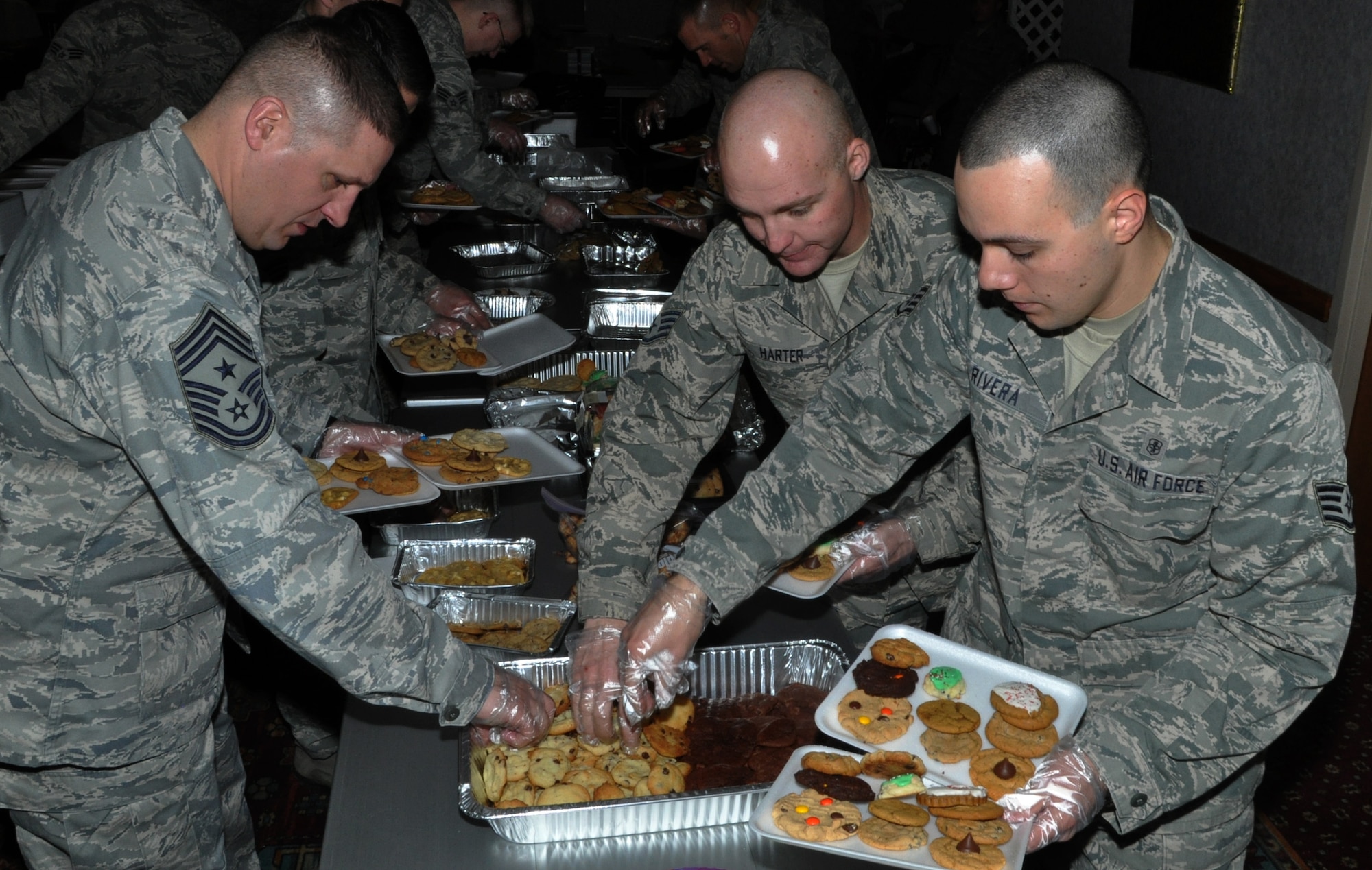 131209-F-CP692-009 Chief Master Sgt. Mike Garrou, 90th Missile Wing command chief; Staff Sgt. Roberto Rivera, 90th Civil Engineer Squadron; and Staff Sgt. Harter, 90th Force Support Squadron; prepare cookie baskets in the Trail’s End Club Dec. 9 during the wing cookie drive. The Air Force association, along with more than 60 volunteers, participated in the creation of more than 500 holiday cookie baskets for the Airmen who reside in the dorms. (U.S. Air Force photo by 1st Lt. Eydie Sakura)