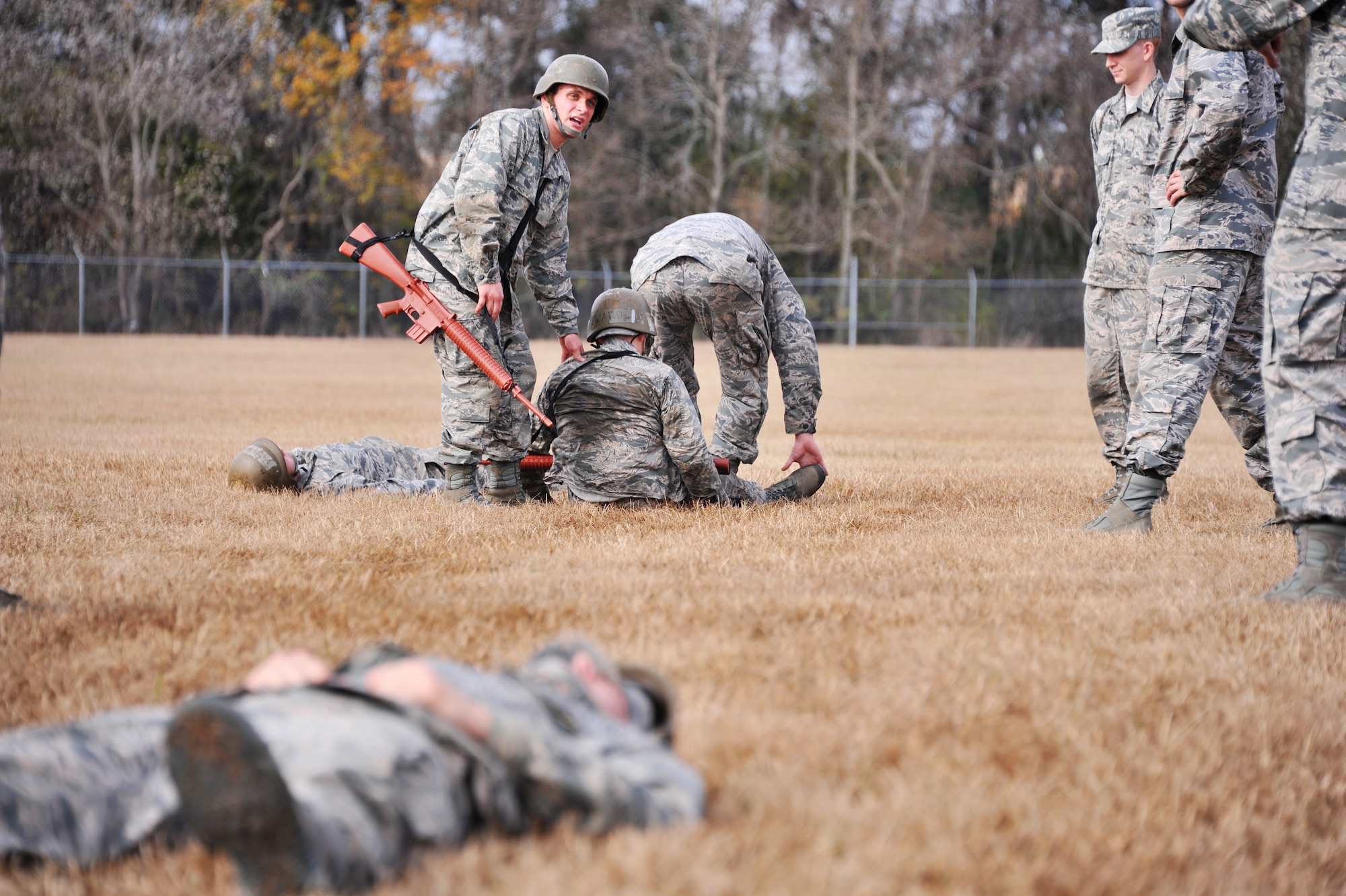 Class 14-03 officer trainees work together to carry their fellow classmates to safety during the basic expeditionary leadership problem solving course Dec. 4, 2013, at Maxwell Air Force Base, Ala. The BELPS course is a part of the first phase of Basic Officer Training School, which is a nine-week long program involving four training phases. During this course the officer candidate students are individually tasked to take lead in solving a problem they would possibly run into in the operational Air Force.  (U.S. Air Force photo by Staff Sgt. Natasha Stannard)