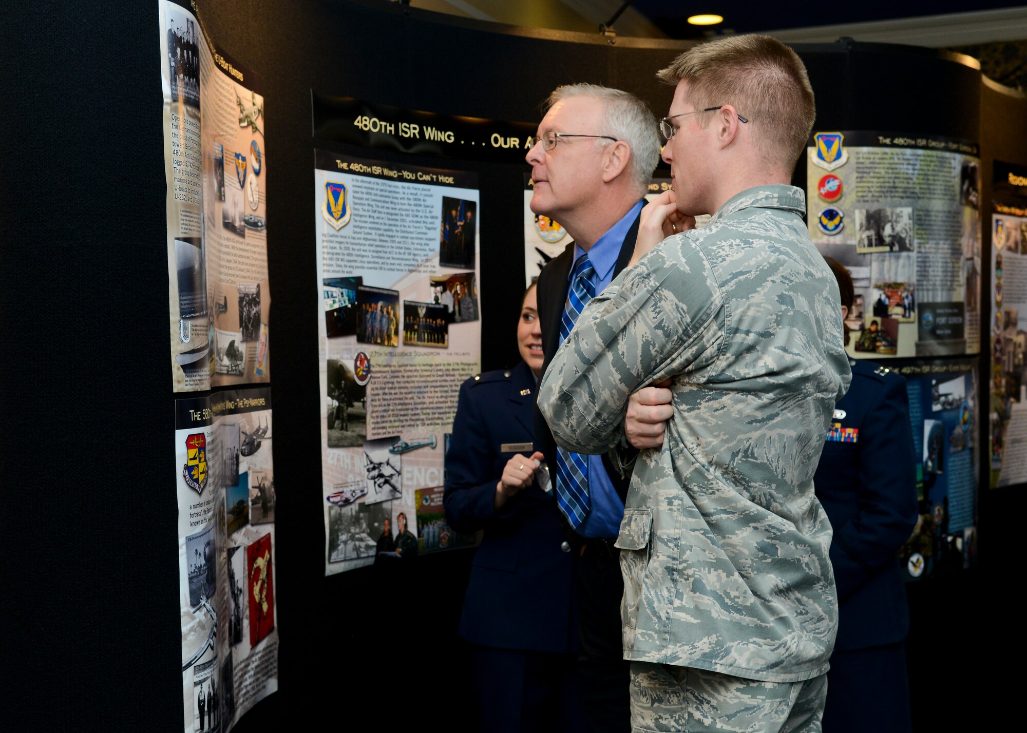 Attendees view a display in honor of the 480th Intelligence, Surveillance and Reconnaissance Wing during the Heritage Observance Celebration at Langley Air Force Base, Va., Dec. 5, 2013. Since Dec. 1, 2003, the 480th ISR Wing has expanded to become the U.S. Air Force leader in globally-networked ISR operations. (U.S. Air Force photo by Airman 1st Class Victoria H. Taylor/Released))