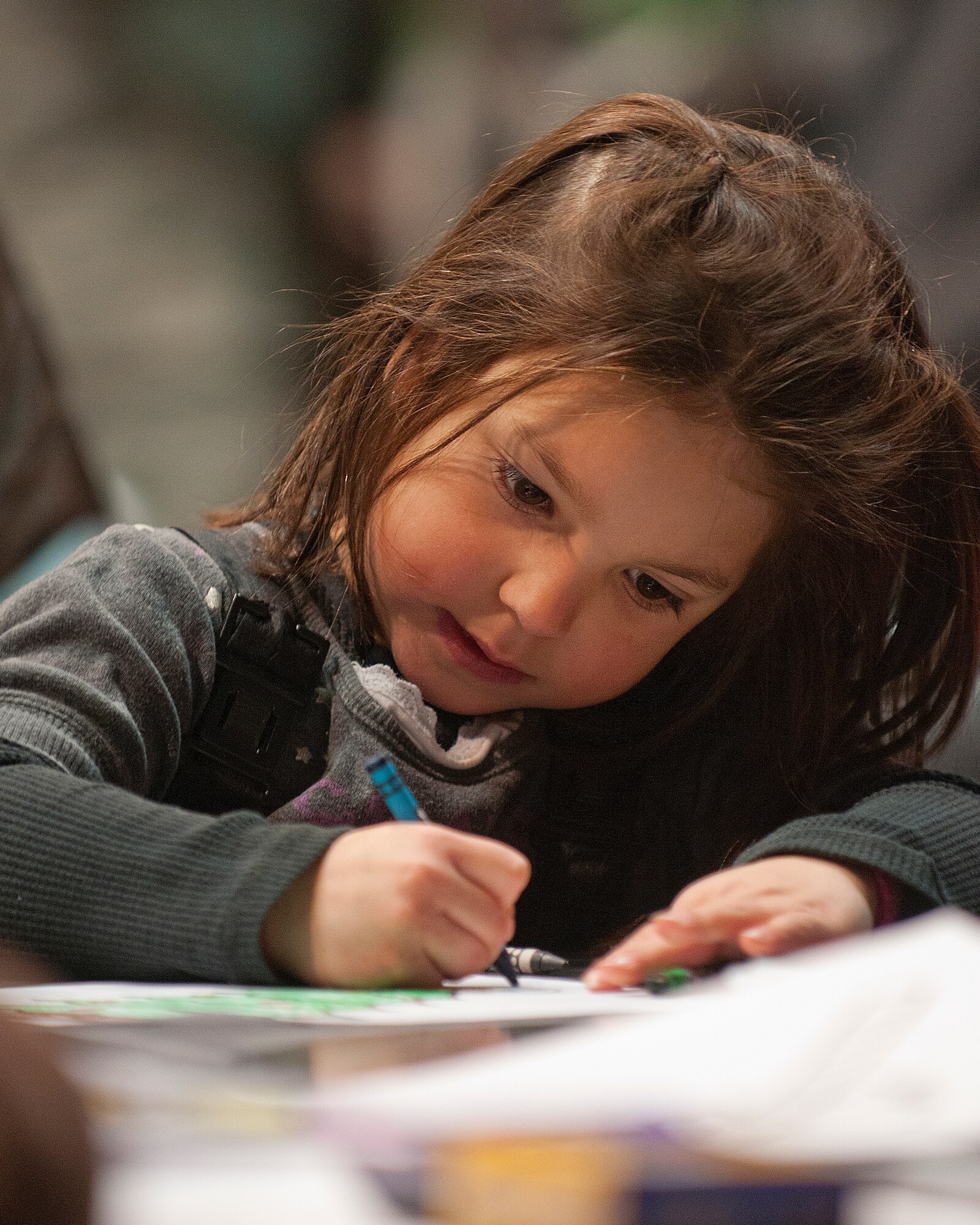 Malia Shirley, 5, colors at one of the crafts tables in the Fall Hall Community Center Dec. 6, 2013. Shirley, the daughter of Tiffany and Staff Sgt. Scott Shirley, 90th Security Forces Group, was taking part in the annual lighting of the Christmas tree. (U.S. Air Force photo by R.J. Oriez)
