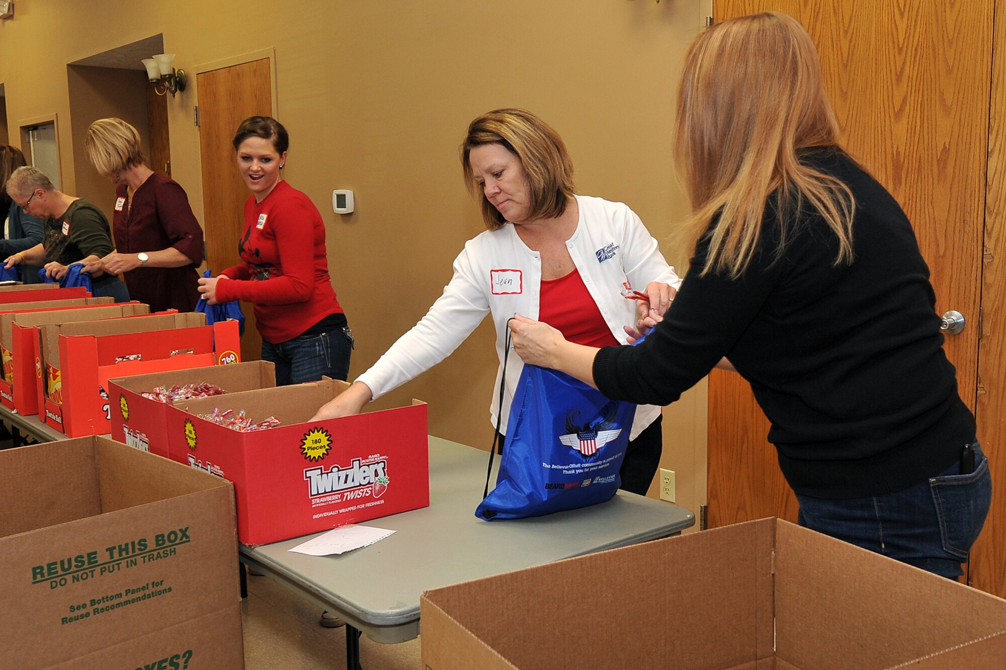 Operation Holiday Cheer volunteers fill gift bags for the dorm residents on Offutt Air Force Base, Neb., during the Operation Holiday Cheer event at the volunteer firefighter hall in Bellevue, Neb., Dec. 6. The gift bags are designed to add holiday cheer to those Airman who are unable to go home during the holiday season. (U.S. Air Force photo by Charles Haymond/Released)