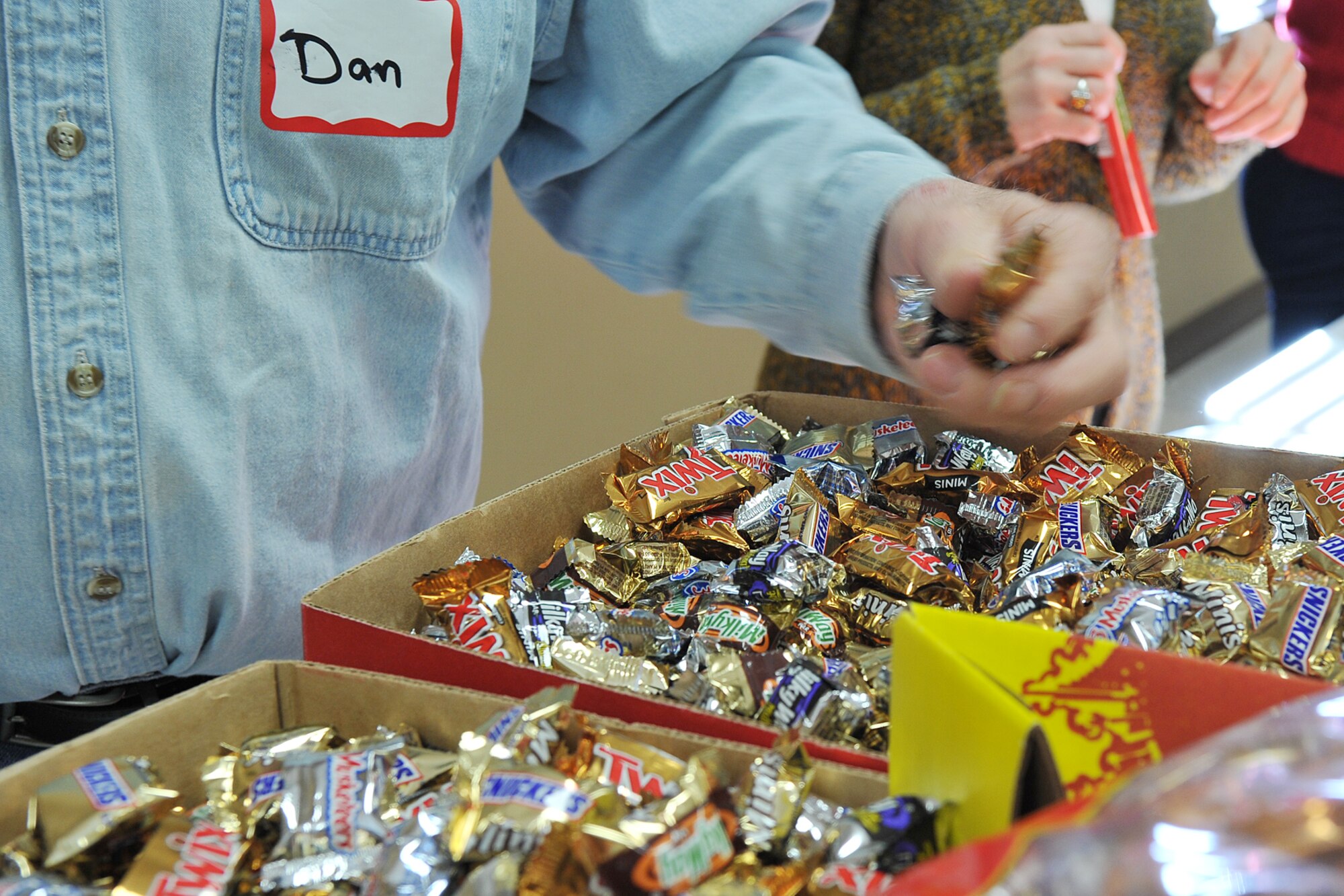 Dan Grouthan, Operation Holiday Cheer volunteer, grabs a handful of candy during the Operation Holiday Cheer event at the volunteer firefighter hall in Bellevue, Neb., Dec. 6. Operation Holiday Cheer is an annual event where volunteers make gift bags filled with donated candy and snacks and a thank you note for dorm residents on Offutt Air Force Base. (U.S. Air Force photo by Charles Haymond/Released)