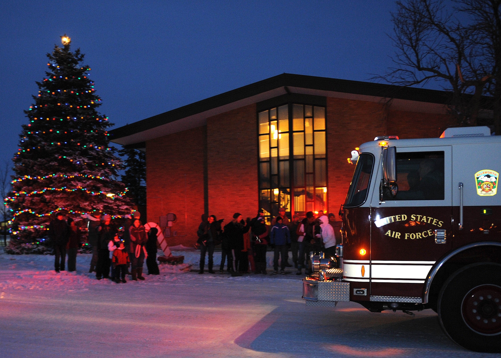 Airmen and families braved sub-sero temperatures and gathered for the 28th Bomb Wing tree lighting ceremony in front of the Freedom Chapel at Ellsworth Air Force Base, S.D, Dec. 4, 2013. The ceremony, which included remarks by Col. Kevin Kennedy, 28th BW commander, carolers, holiday goodies, and a visit by Santa Claus, who arrived by fire truck. (U.S. Air Force Photo my Airman 1st Class Rebecca Imwalle / Released)