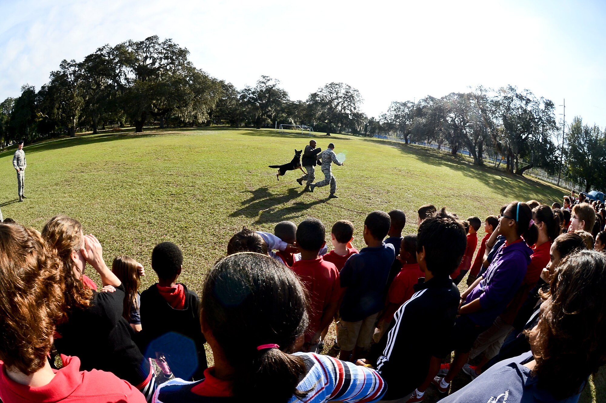 Tampa Adventist Academy students watch a military working dog demonstration performed by members from the 6th Security Force Squadron MWD section, Dec. 4, 2013, in Tampa, Fla. The demonstration exhibited the six phases of controlled aggression, which consist of a false run, a bite and hold, a search, an escort, a standoff and a re-attack. (U.S. Air Force photo by Senior Airman Melanie Bulow-Gonterman/Released)