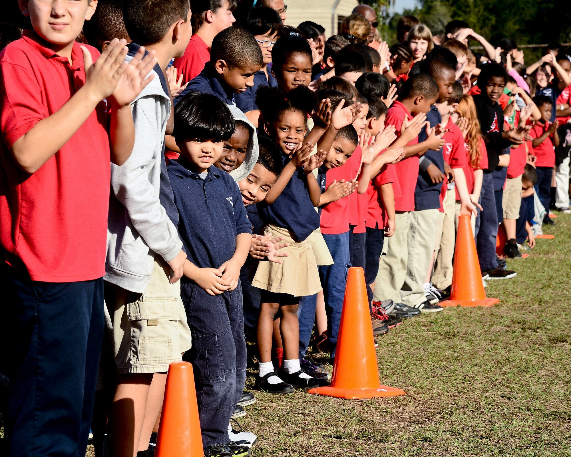 Tampa Adventist Academy students applaud a military working dog demonstration performed by members from the 6th Security Force Squadron MWD section, Dec. 4, 2013, in Tampa, Fla. This was the first time Tampa Adventist Academy held an event of this nature. (U.S. Air Force photo by Senior Airman Melanie Bulow-Gonterman/Released)