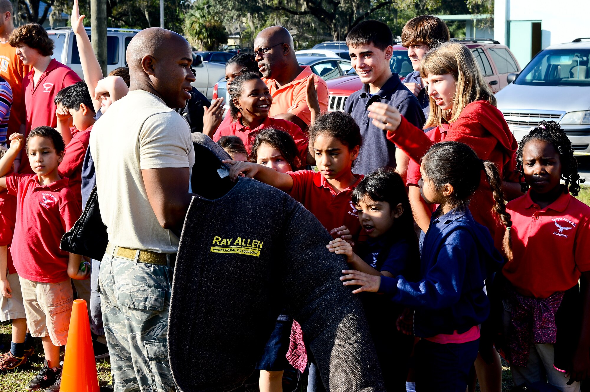 Tampa Adventist Academy students feel the texture of a bite suit after a military working dog demonstration performed by members from the 6th Security Force Squadron MWD section, Dec. 4, 2013, in Tampa, Fla. The demonstration exhibited the six phases of controlled aggression, which consist of a false run, a bite and hold, a search, an escort, a standoff and a re-attack.   (U.S. Air Force photo by Senior Airman Melanie Bulow-Gonterman/Released)
