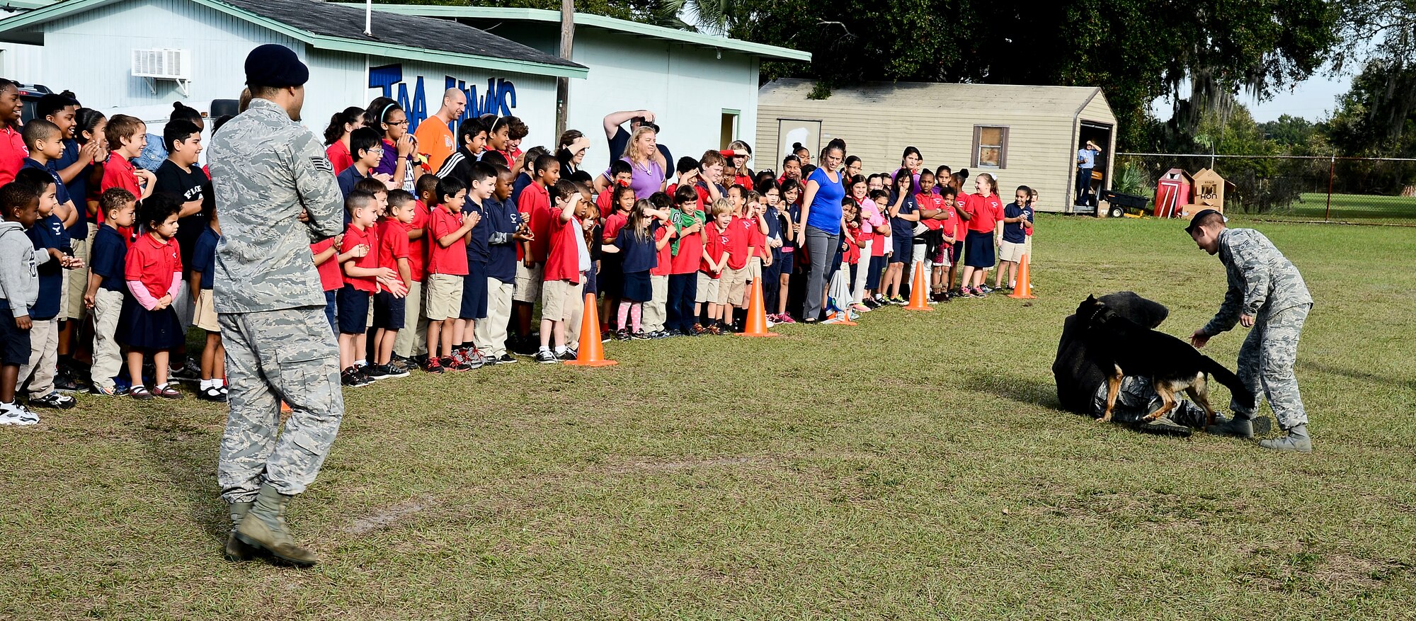 Tampa Adventist Academy students watch a military working dog demonstration performed by members from the 6th Security Force Squadron MWD section, Dec. 4, 2013, in Tampa, Fla. The demonstration exhibited the six phases of controlled aggression, which consist of a false run, a bite and hold, a search, an escort, a standoff and a re-attack. (U.S. Air Force photo by Senior Airman Melanie Bulow-Gonterman/Released)
