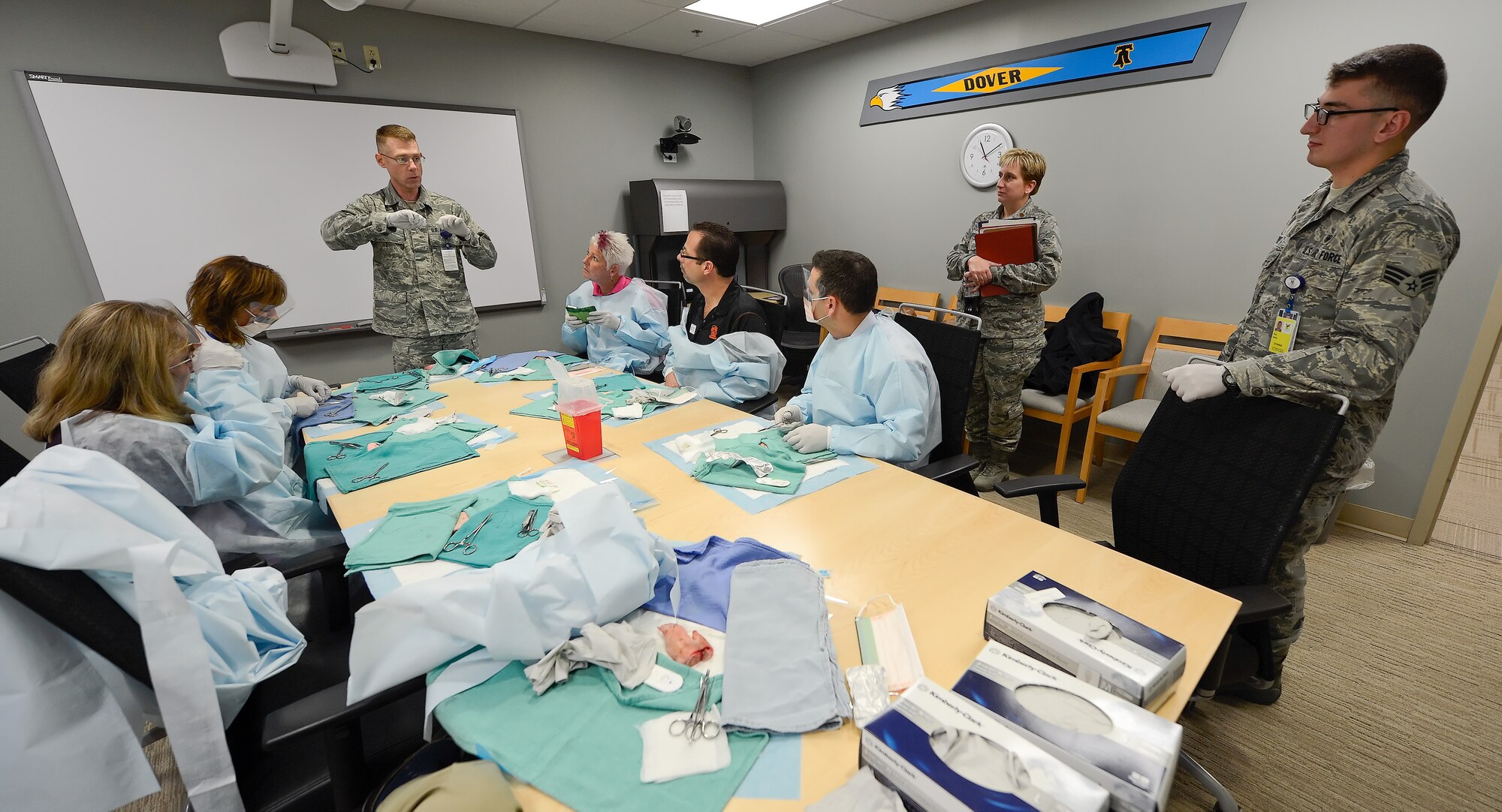 Master Sgt. Randall Cross, an intermediate duty medical technician, discusses how to suture wounds while a group of honorary commanders and other medical technicians look on Dec. 4, 2013, at Dover Air Force Base, Del. Honorary commanders participated in the hands-on demonstration during a tour of the 436th Medical Group. (U.S. Air Force photo/Greg L. Davis)