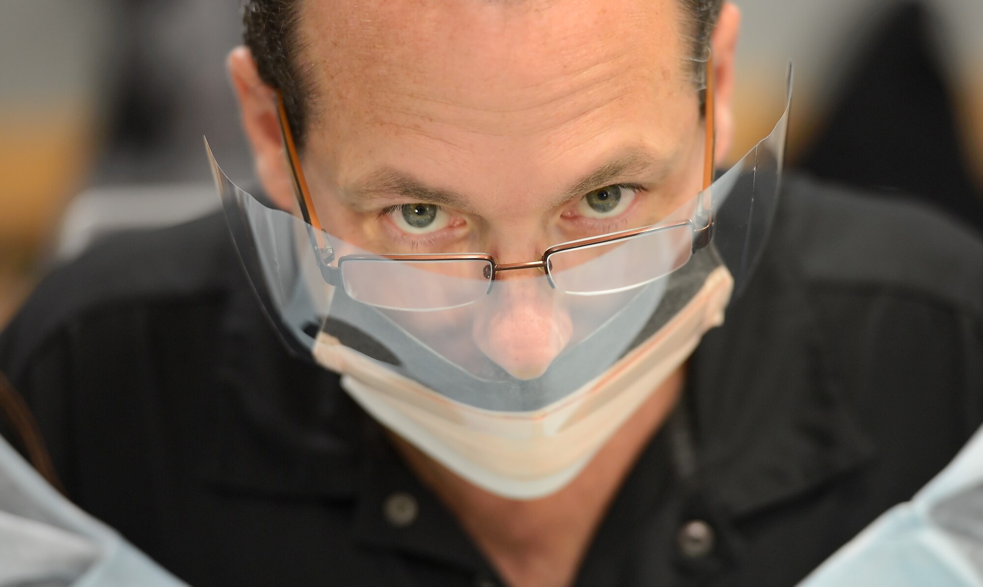 John Yoho, 436th Operations Support Squadron honorary commander, looks over his protective face shield while participating in a hands-on learning experience within the 436th Medical Group, Dec. 4, 2013, on Dover Air Force Base, Del. Honorary Commanders received an in-depth tour of the unit to better understand their mission capabilities. (U.S. Air Force photo/Greg L. Davis)