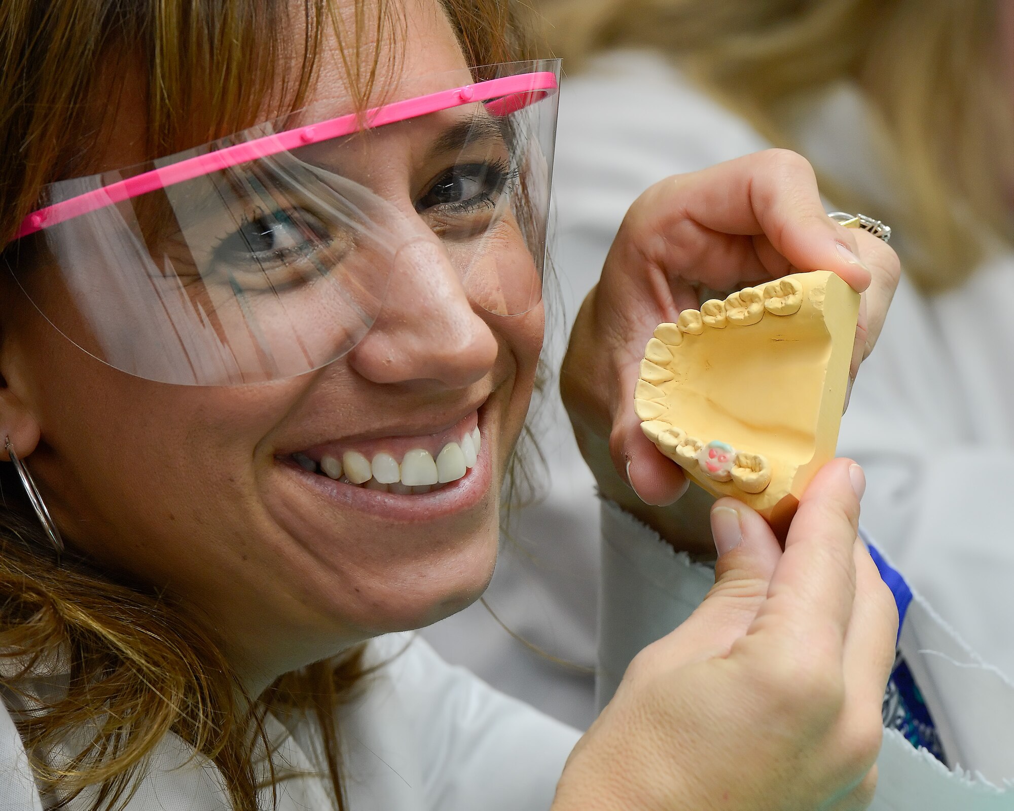 Lori Ewald, 436th Contracting Squadron honorary commander, smiles as she shows off the smiley-face she made using different colored wax in a tooth mold Dec. 4, 2013, at the Dental Clinic on Dover Air Force Base, Del. The Honorary Commanders received an in-depth tour of the 436th Medical Group and the opportunity for hands-on learning. (U.S. Air Force photo/Greg L. Davis)
