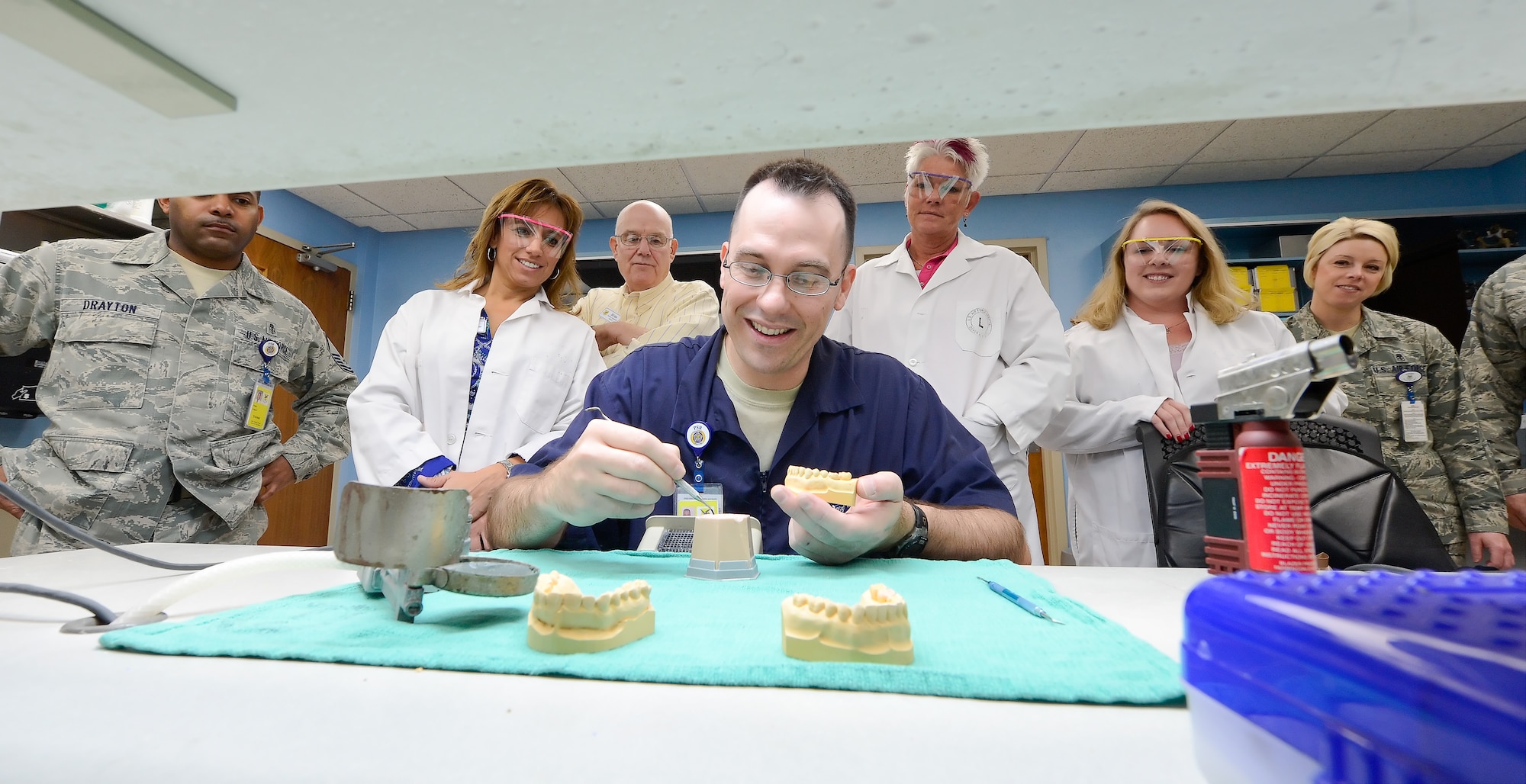 Master Sgt. Kevin P. Keens, 436th Dental Squadron, dental laboratory technician, demonstrates how to build a tooth mold using wax while a group of Dover Air Force Base Honorary Commanders look on Dec. 4, 2013, at the Dental Clinic on Dover AFB, Del. The honorary commanders were given a tour of the 436th Medical Group so they could better understand the units' mission and capabilities.(U.S. Air Force photo/Greg L. Davis)