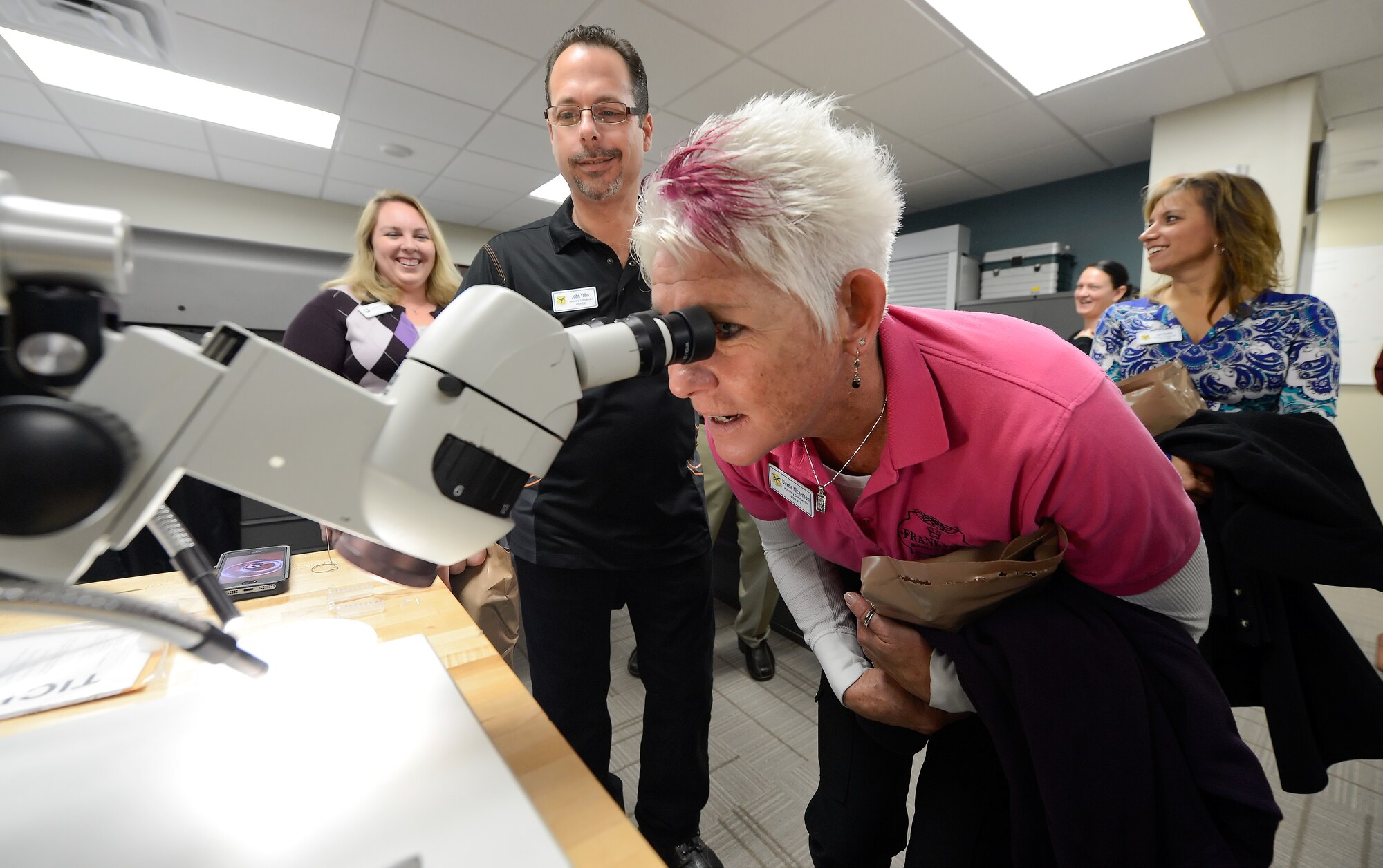 Dawne Nickerson, 436th Aerial Port Squadron honorary commander, looks into a microscope during an in-depth tour of the 436th Medical Group on Dec. 4, 2013, at Dover AFB, Del. The honorary commanders were given the opportunity for some hands-on learning so they could better understand the units' mission and capabilities. (U.S. Air Force photo/Greg L. Davis)