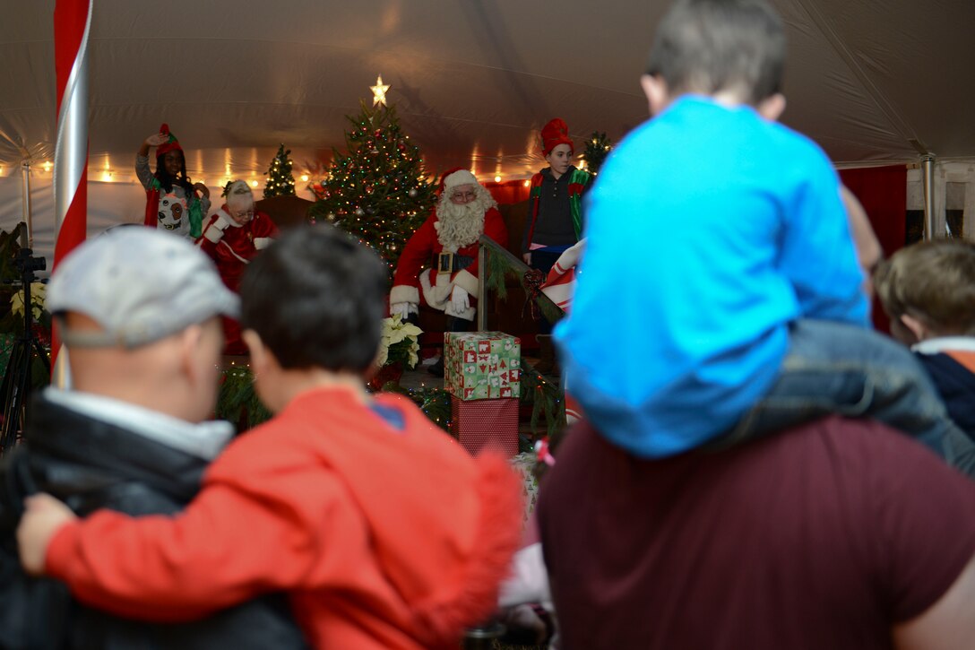 Families wait in line for their chance to sit with Santa Claus after the Christmas tree lighting ceremony at Fort Eustis, Va., Dec. 6, 2013. After the tree-lighting, guests enjoyed snacks, holiday music and a visit with Santa’s elves. (U.S. Air Force photo by Staff Sgt. Ciara Wymbs/Released)
