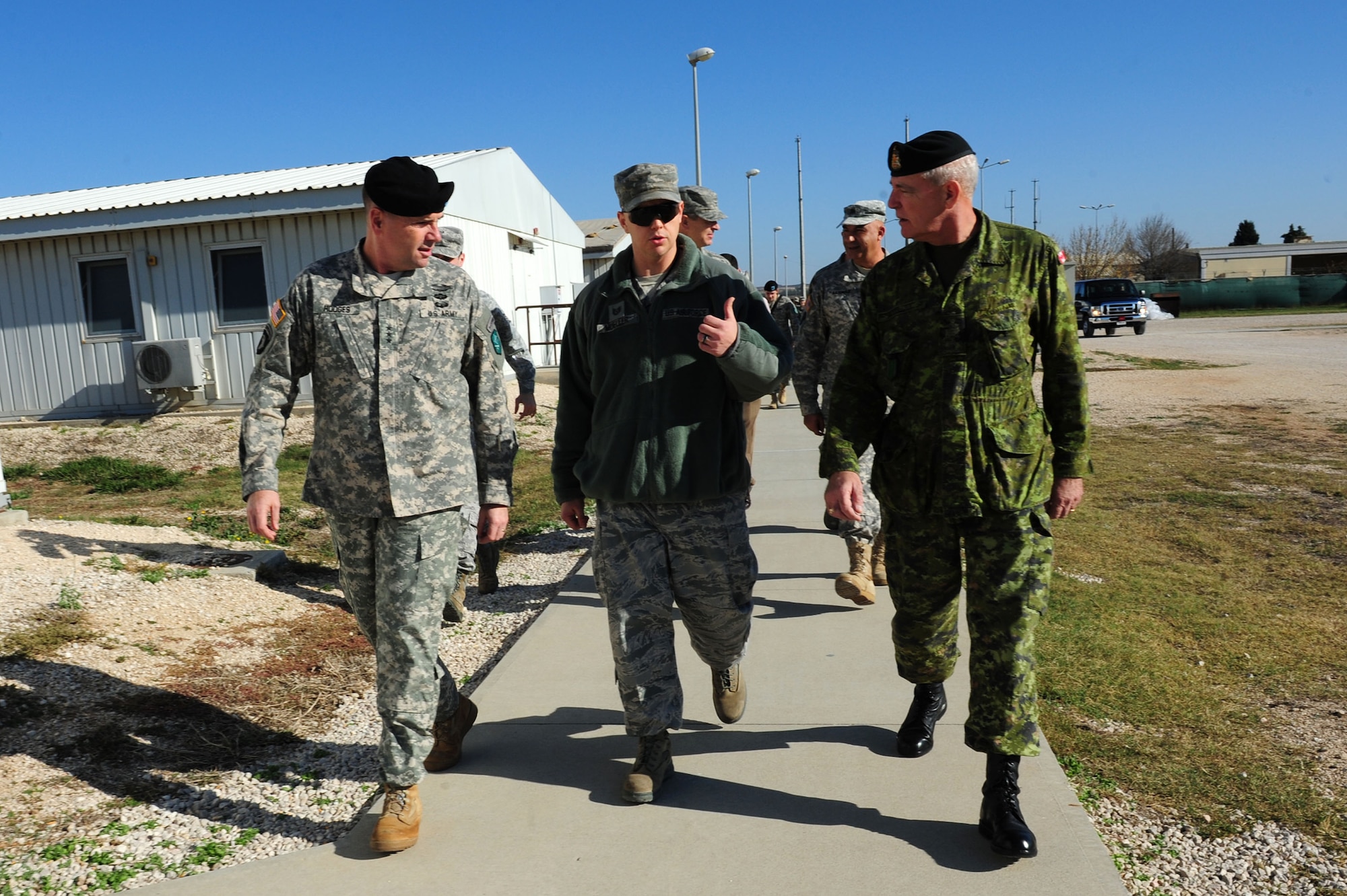 U.S. Army Lt. Gen. Frederick "Ben” Hodges, commander of NATO’s Allied Land Command, Tech. Sgt. Aron Mueller, 39th Force Support Squadron NCO in charge of Patriot Village, and Canadian army Chief Warrant Officer Mark Saulnier, the command sergeant major of Allied Force Command Heidelberg, walk through Patriot Village Dec. 9, 2013, at Incirlik Air Base, Turkey.  Mueller and Dutch soldiers showed the NATO LANDCOM leaders the medical clinic and the Holland House, where deployed service members spend their free time. (U.S. Air Force photo by Airman 1st Class Nicole Sikorski/Released) 